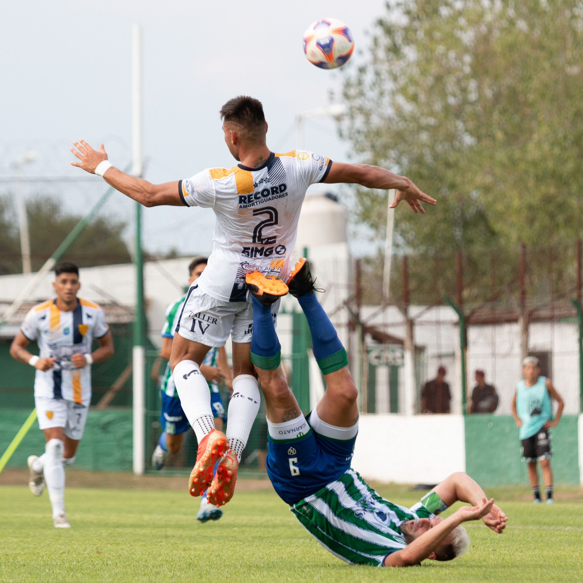 Enzo Tamborelli (Dock Sud) cabecea la pelota mientras Lucas Scarnato (San Miguel) cae al césped. El 19 de marzo de 2023 en el Estadio Malvinas Argentinas de Los Polvorines, Buenos Aires, Argentina. Dock Sud logró romper la racha invicta del torneo de San Miguel luego de derrotarlos 2 a 1 en los minutos finales del partido por la Fecha 6 del Torneo Apertura de la Primera B.