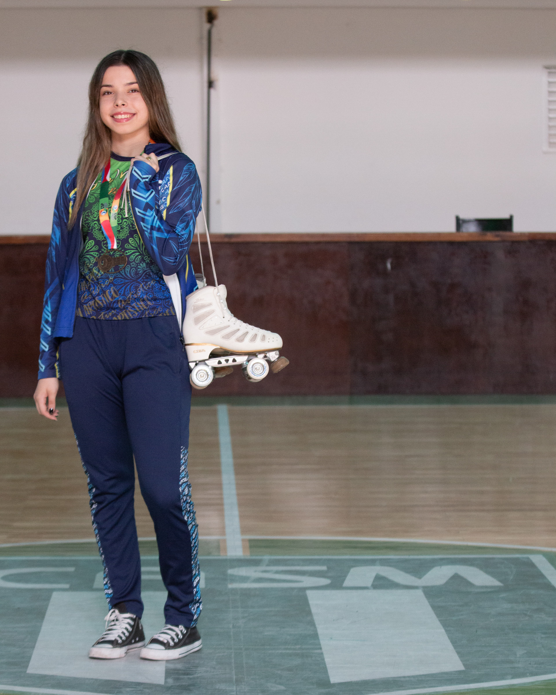 Delfina Corbo posa con sus patines y la medalla por ser campeona sudamericana de patín en la categoría promocional básico junior 2023. 