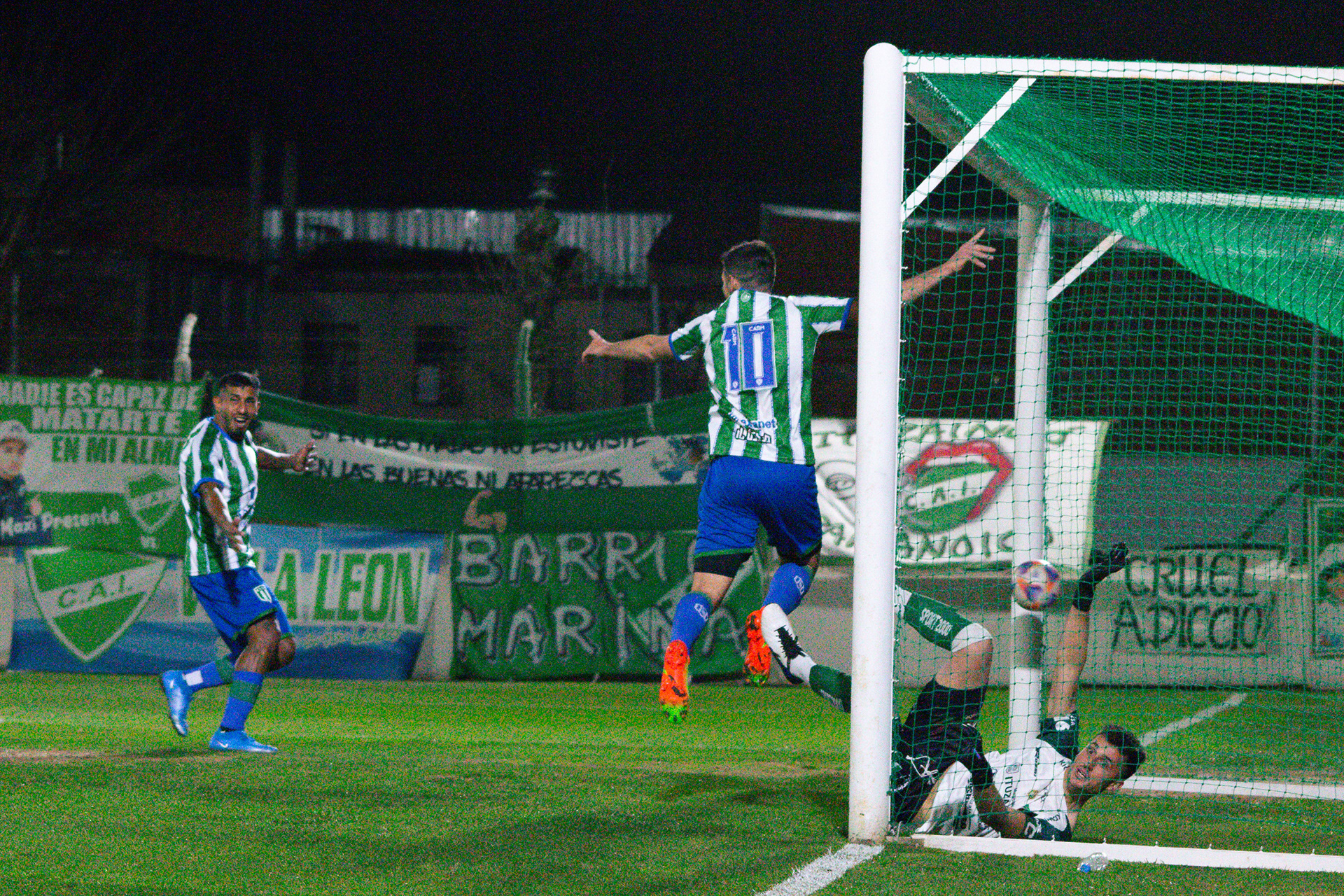 Jorge Ferrero marca el primer gol del partido frente a Ituzaingó, mientras Cristian Chavez lo acompaña y el arquero rival sufre la caída. El 19 de agosto de 2023 en el Estadio Carlos Sacaan de Ituzaingó, Buenos Aires, Argentina.