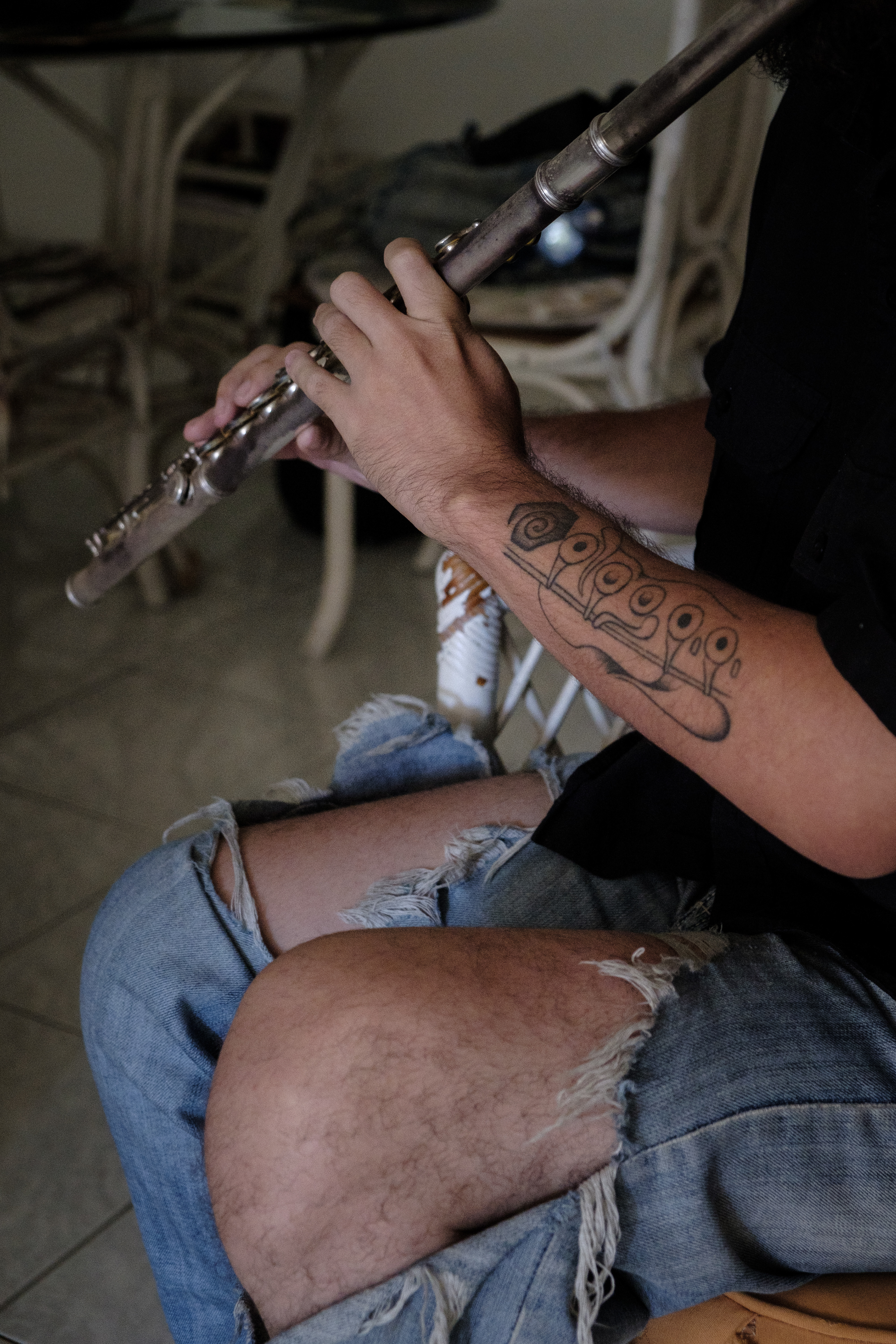 Bryan Carrer, 28, friends with Jose David plays the flute at his appartment where they meet to study the sound of things. both met in Margarita Island, another state of Venezuela where they grew up. Caracas April 5, 2019