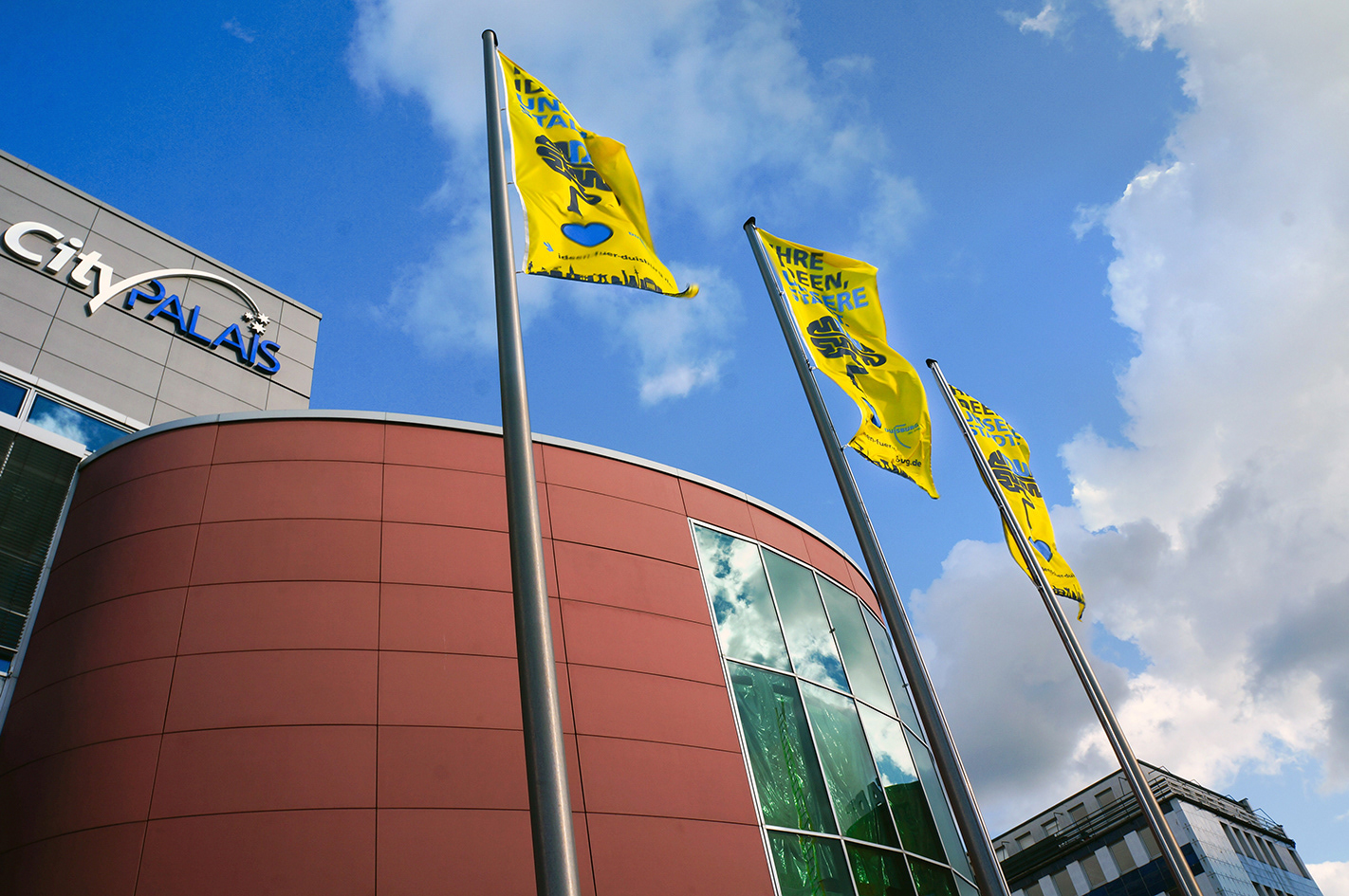 Bestückung der Fahnenmaste am CityPalais der Duisburger Innenstadt