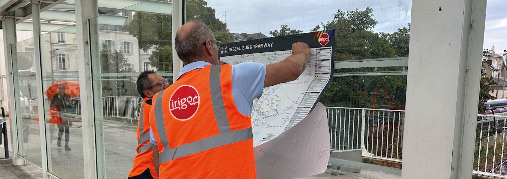 photo de la pose des affiches dans les cadres des stations tram du réseau irigo Angers