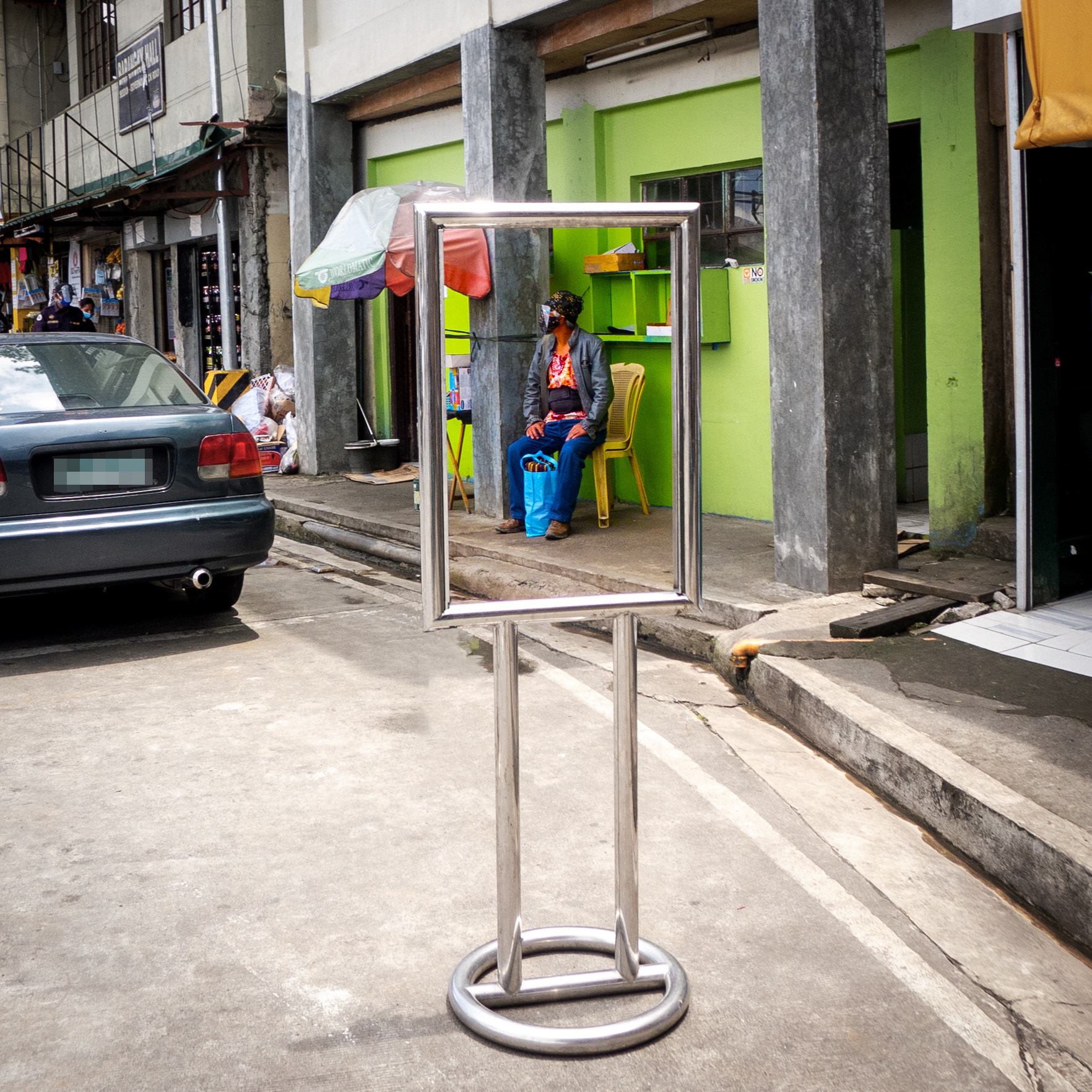 THE NEW FACE OF A BUSINESS AD. For every business establishment closing down, a struggling worker fills the space of a once-thriving poster ad. A sad but true reality. Lumix LX5.