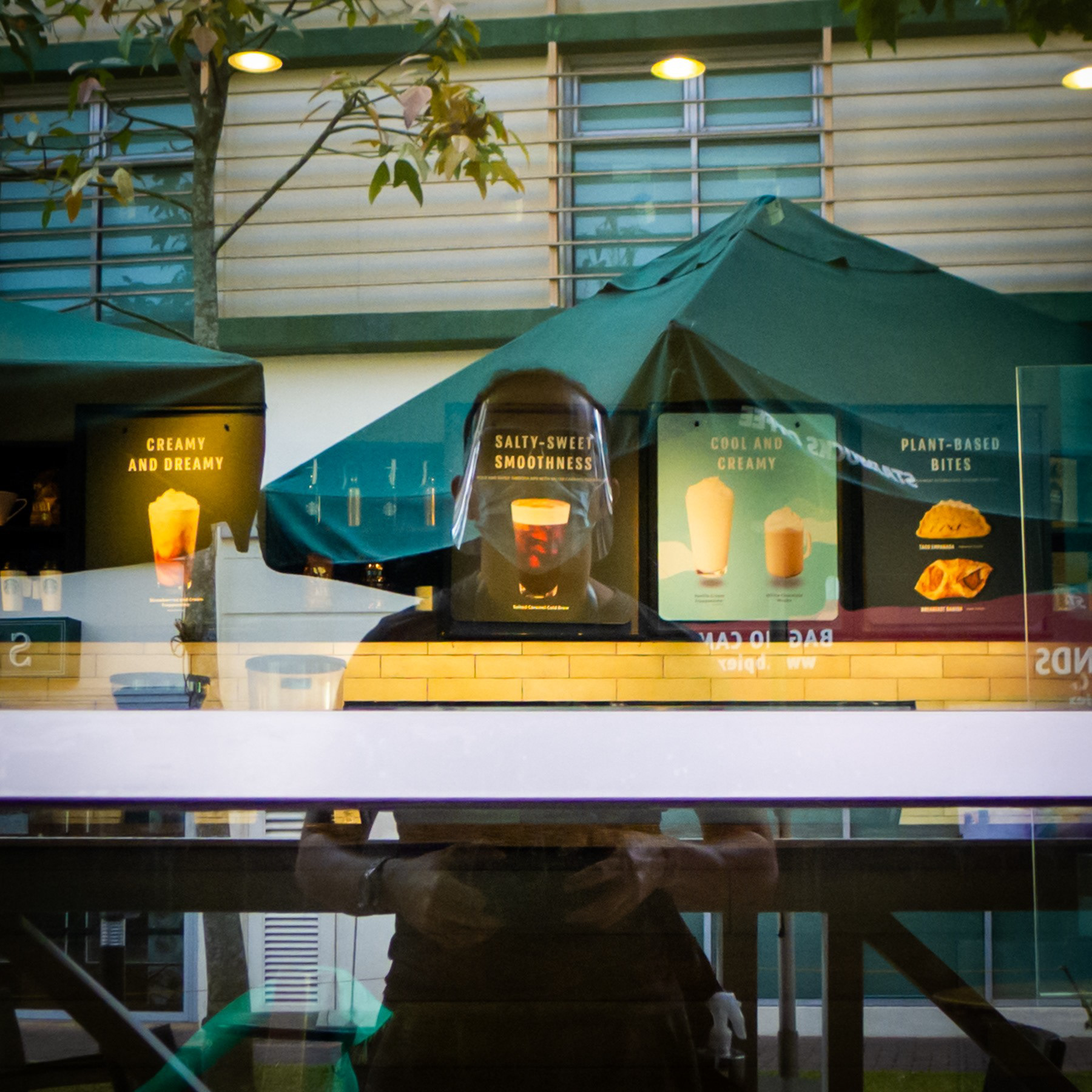 Photographer reflected. A glass panel at Starbucks, CJH. Lumix LX5.