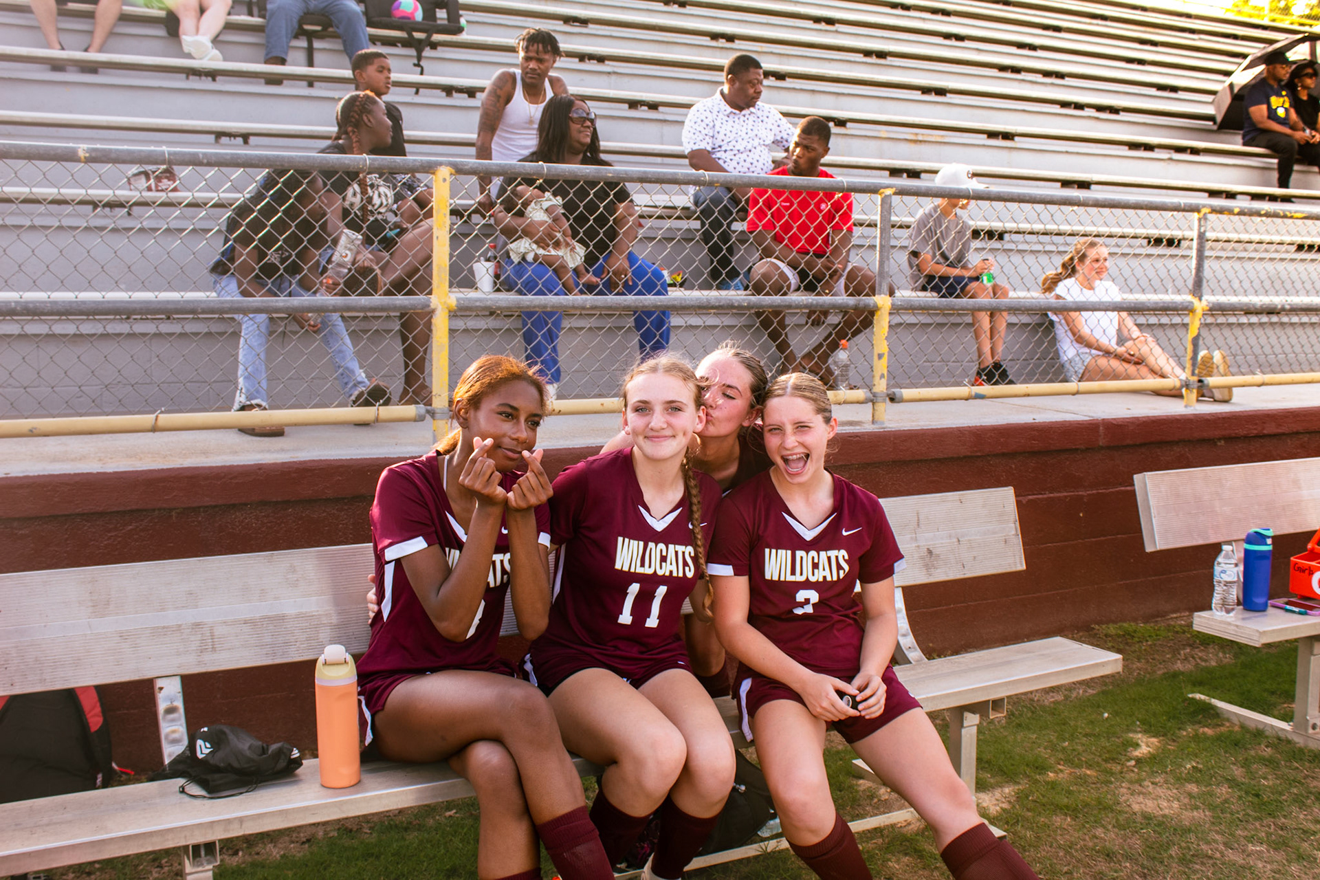 Four players pose for a picture on the bench