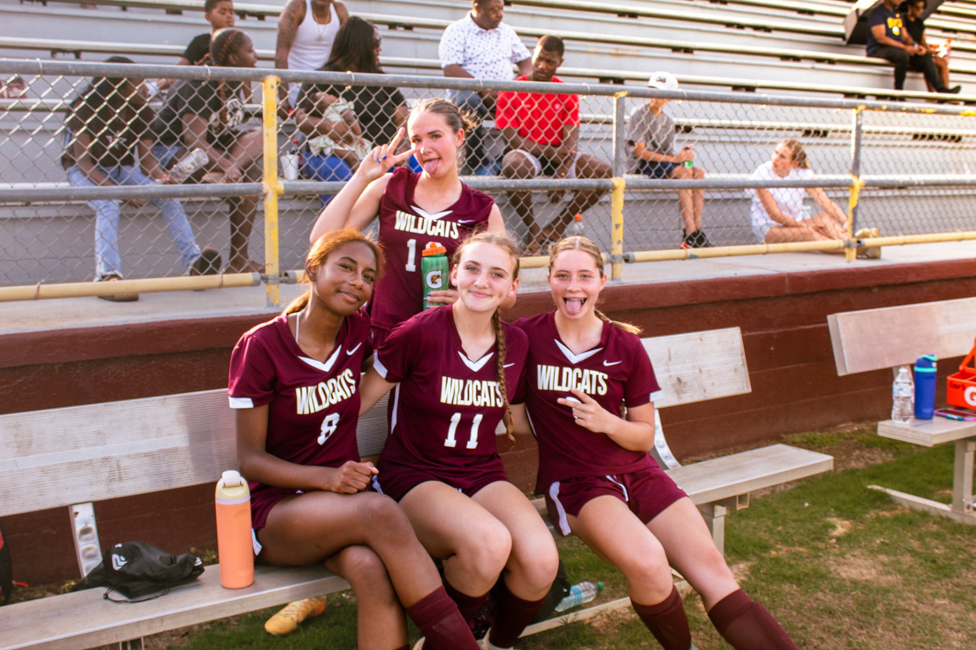Four players pose for a picture on the bench