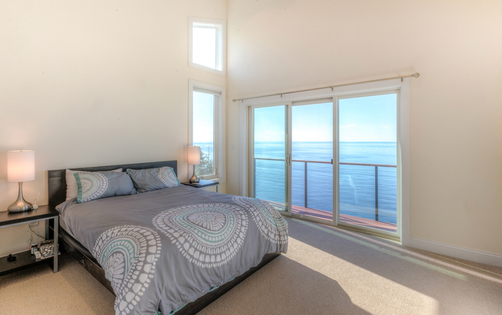 Bedroom in modern home with sliding glass doors viewing the Long Island Sound.