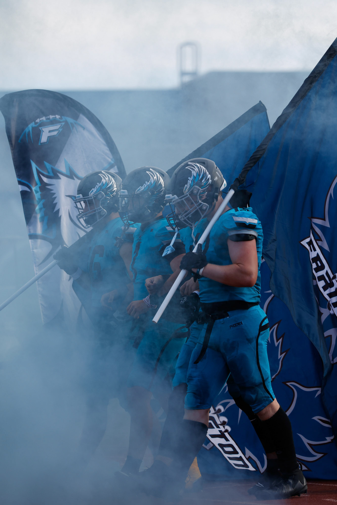 Farmington Captains enter the field carrying their team flags as Farmington looks to host the Bountiful Redhawks.