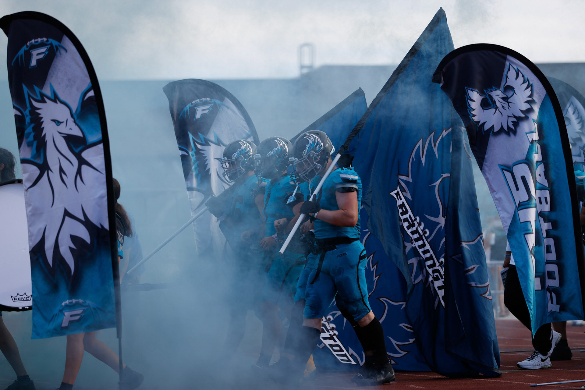Farmington Captains enter the field carrying their team flags as Farmington looks to host the Bountiful Redhawks.