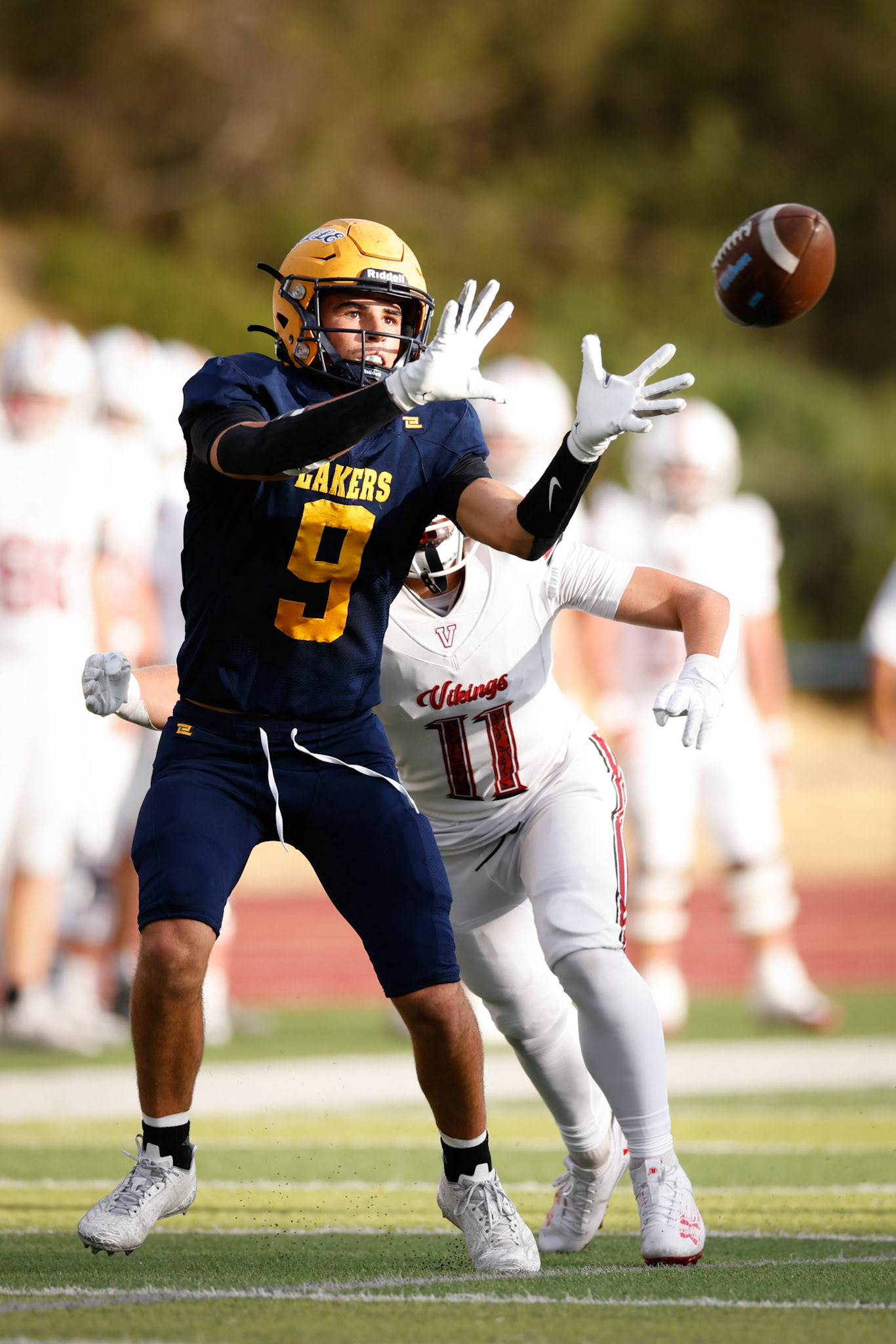 Bonneville WR Lincoln Brooks (9) makes a catch as Viewmont CB Brady Clegg (11) closes for a tackle.