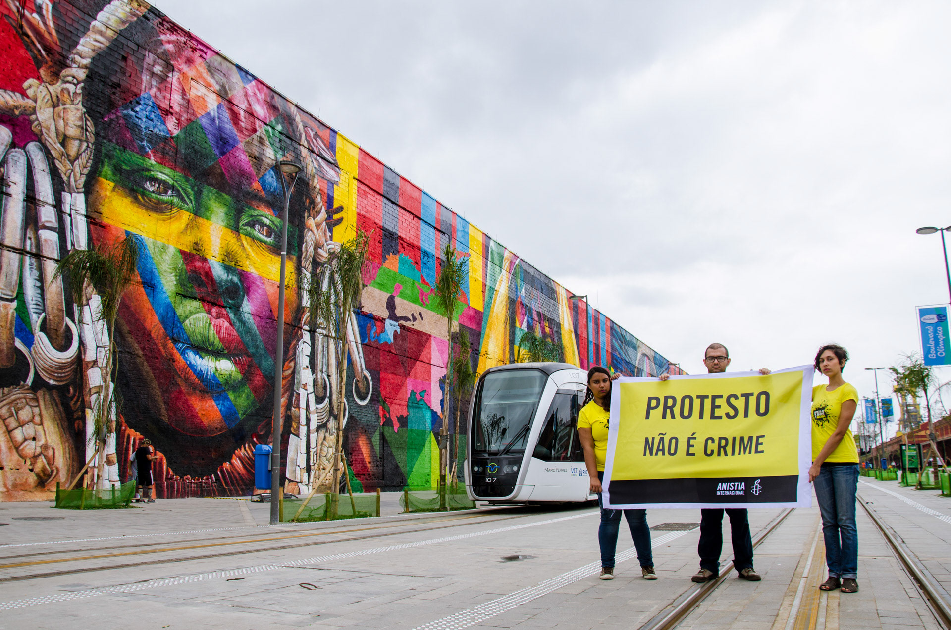 Activists hold a sign 'To Protest Is Not A Crime' at the Olympic Boulevard, one of Rio's postcards - Aug 2016
