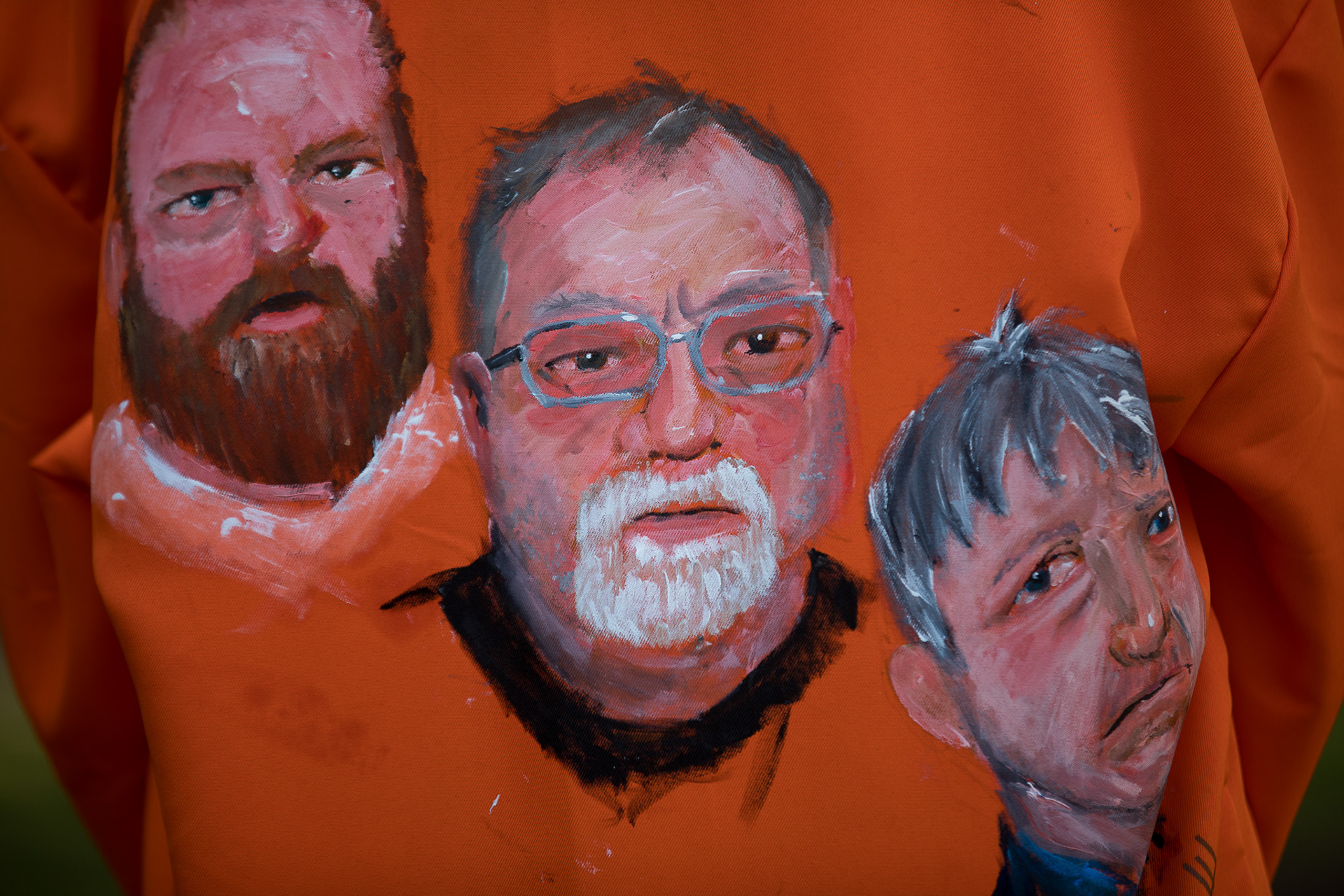 The faces of Gregory McMichael, Travis McMichael and Willian Bryan are painted onto the back of a prison jumpsuit during a demostration in Brunwisk, Ga. ahead of the trial of the three men who are charged with the murder of Ahmaud Arbery.