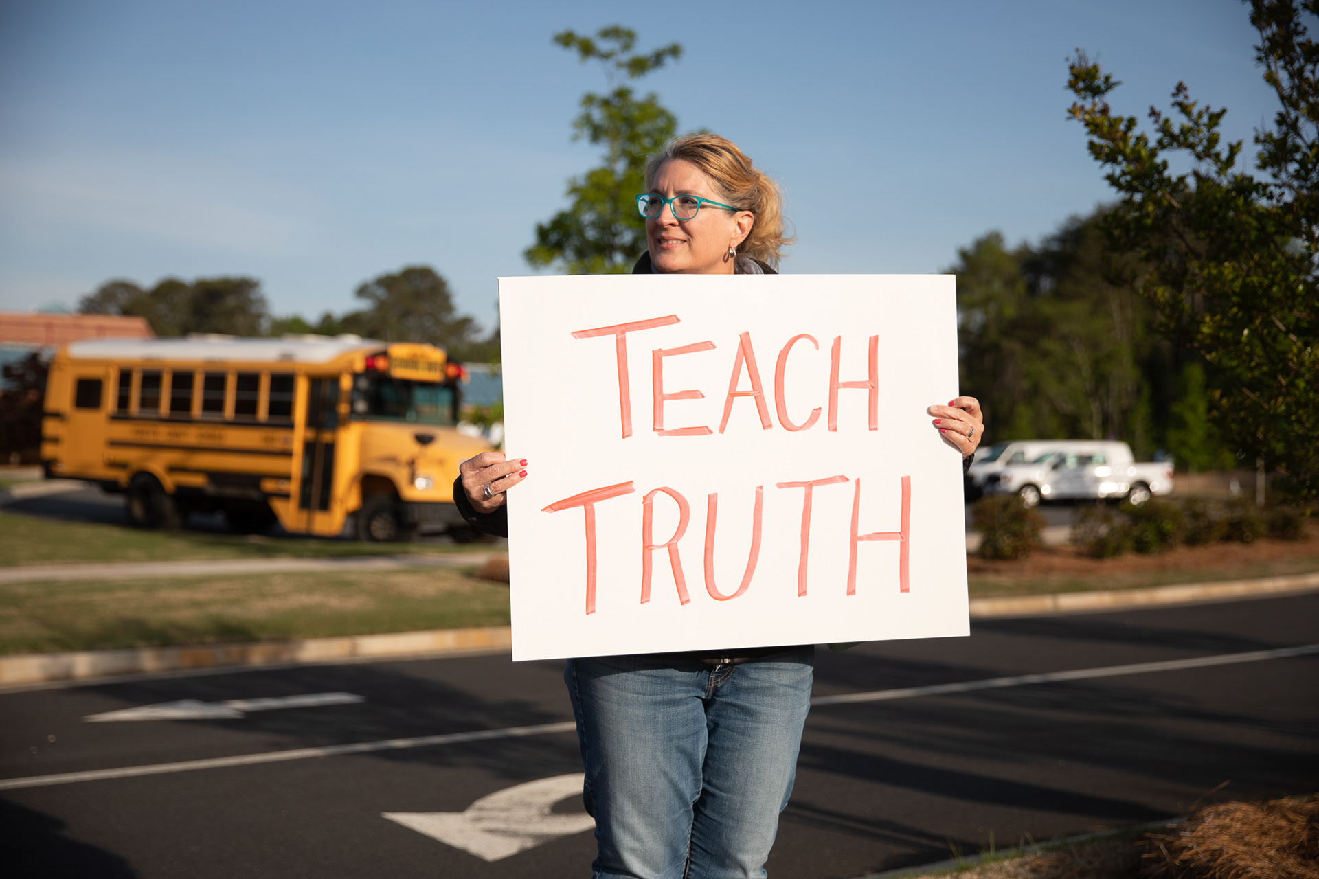 A group of protestors gathers in Forsyth County ahead of Gov. Brian Kemp signing a group of conservative education bills, including a measure that limits conversations about race in classrooms.