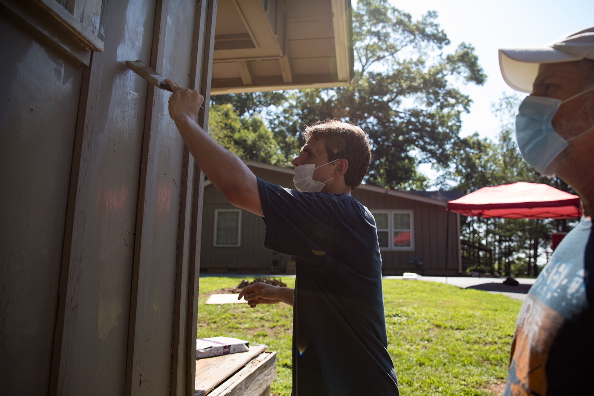 On July 18, Evan and Philip Woody help fellow members paint an old house on the grounds of the North Atlanta Church of Christ in Dunwoody. 
