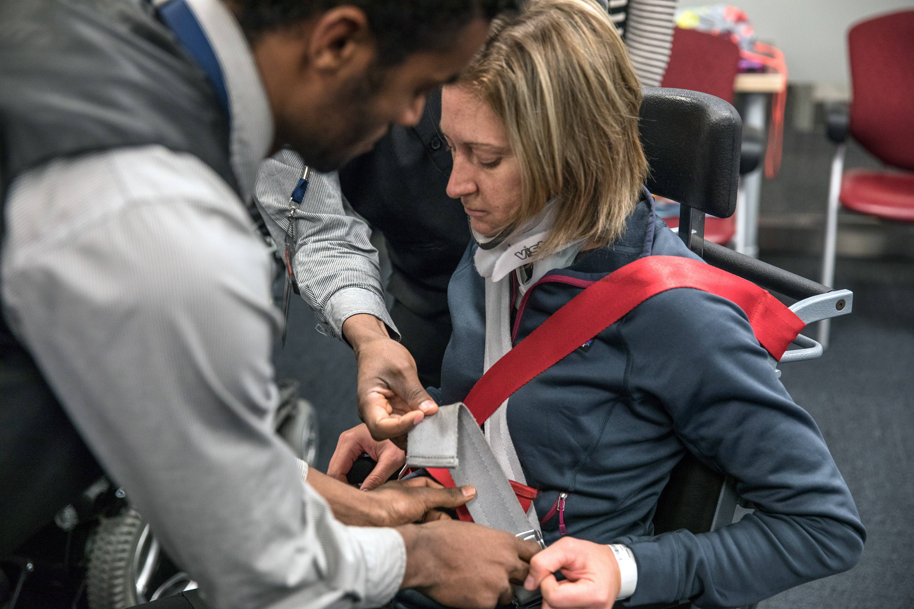 Nikeela Black is shown how airport staff transfer wheelchair users into aisle seats at the Denver International Airport on Oct. 18.