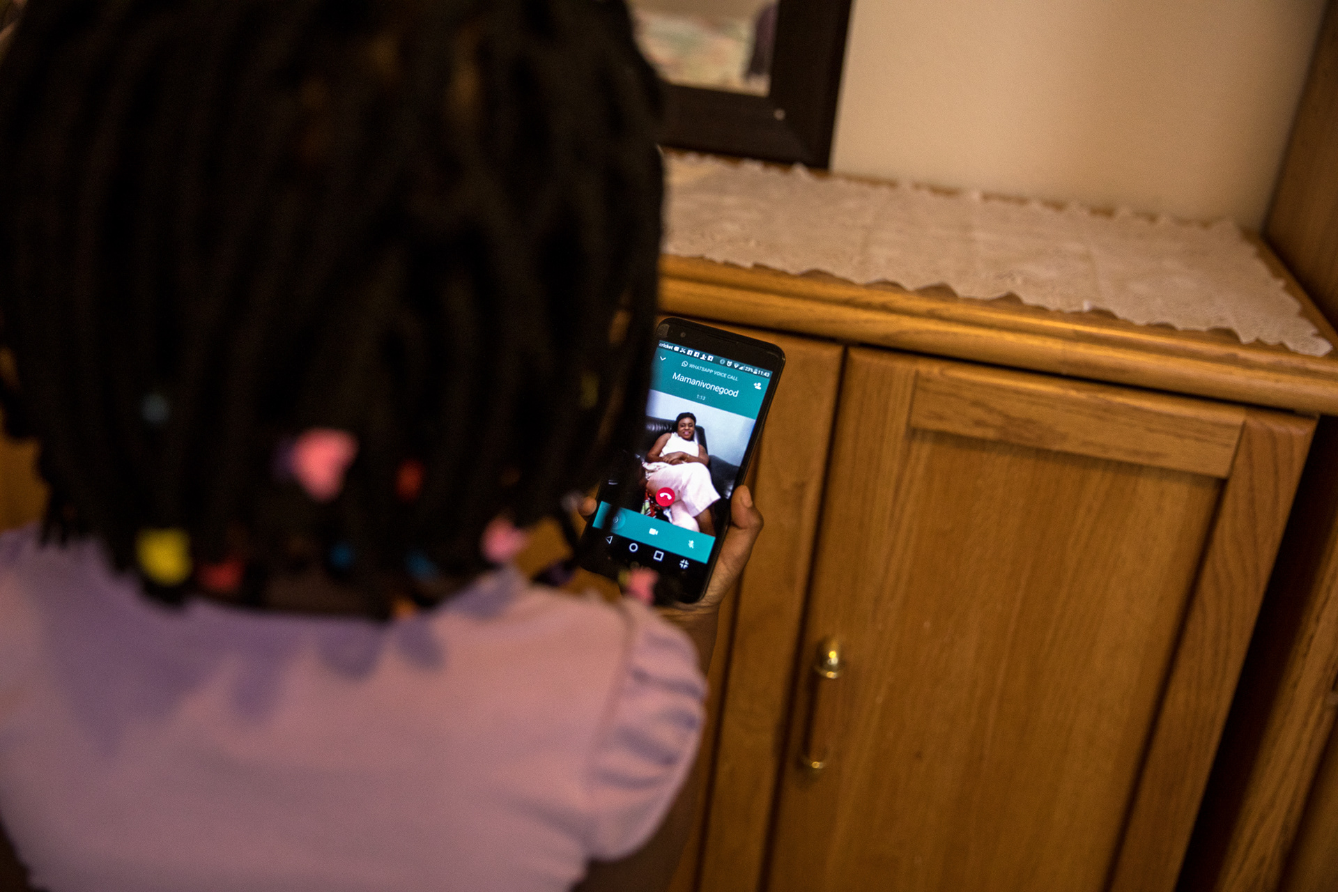Hagath Mwamba's daughter, Angel, 5, talks to her sister Ornelie on the phone on Feb. 6 in Boise.