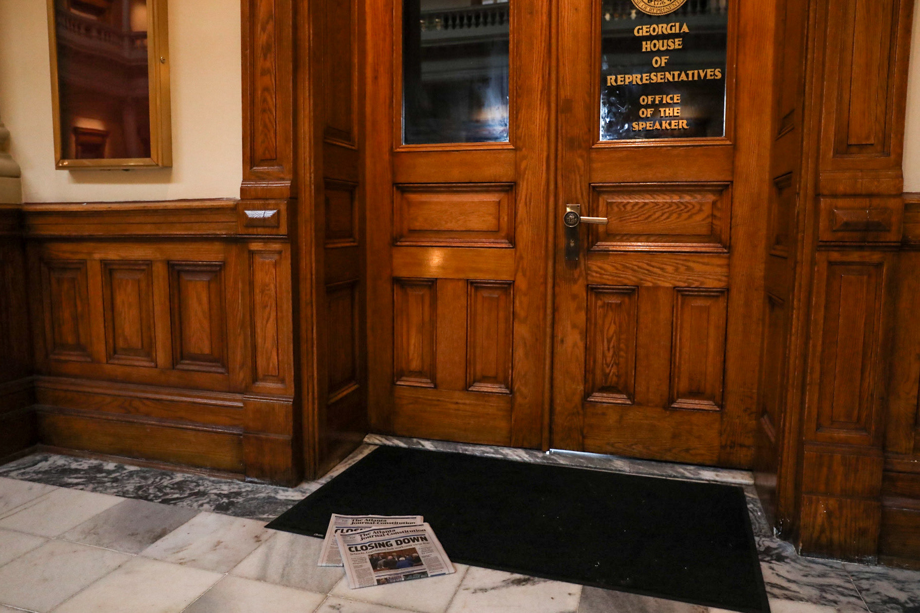The Atlanta Journal-Constitution from March 13 sits on the mat in front of the Office of the Speaker at the Georgia State Capitol, the day after the Georgia General Assembly Announced it was to suspend amid coronavirus concern. 
