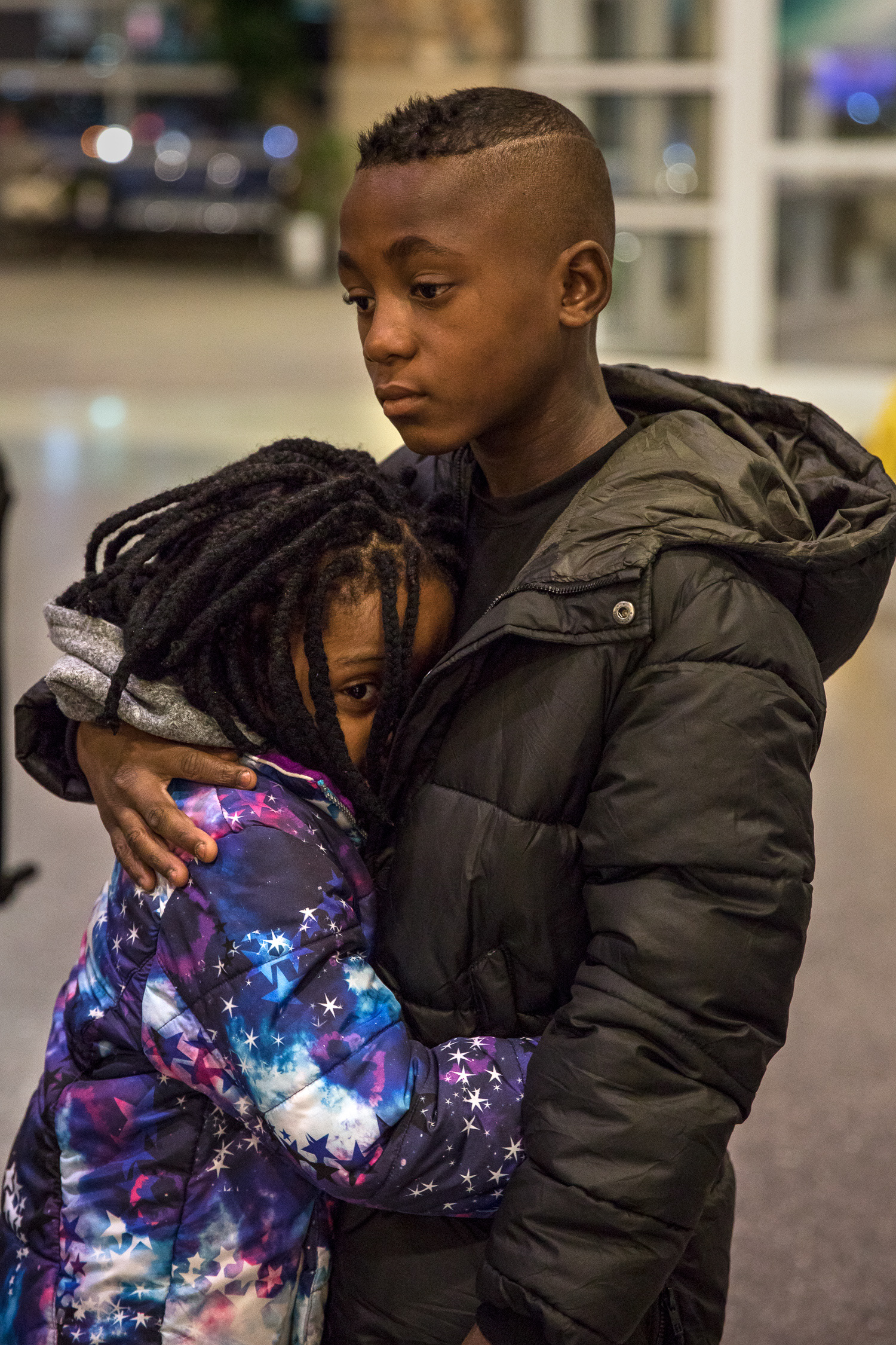 Patient, 9, hugs his sister Mary Grace, 3, in the Boise Airport on March 6.