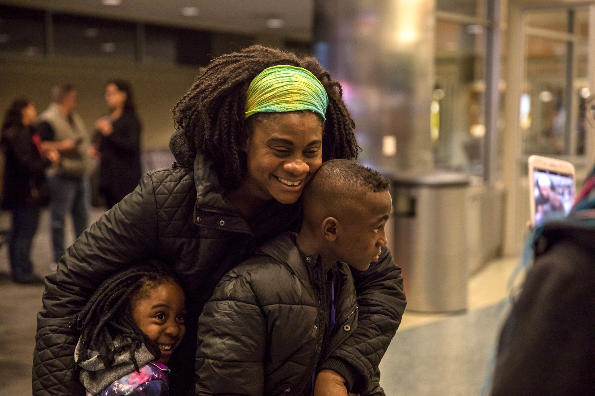 Aminata Konate hugs her son, Patient, 9, and daughter Mary Grace, 3, in the Boise Airport on March 6.