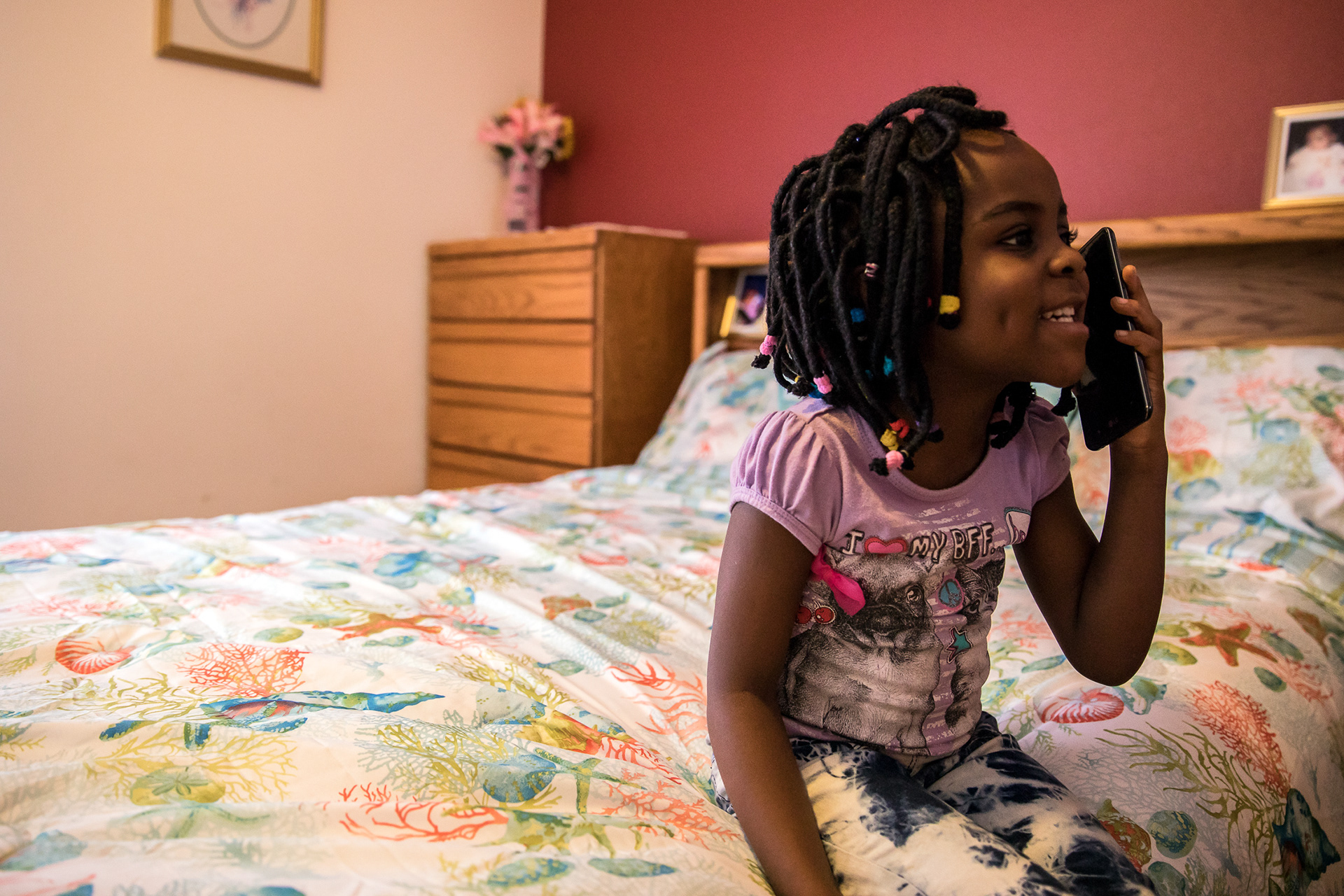 Hagath Mwamba's daughter, Angel, 5, talks to her sister Ornelie on the phone on Feb. 6 in Boise.