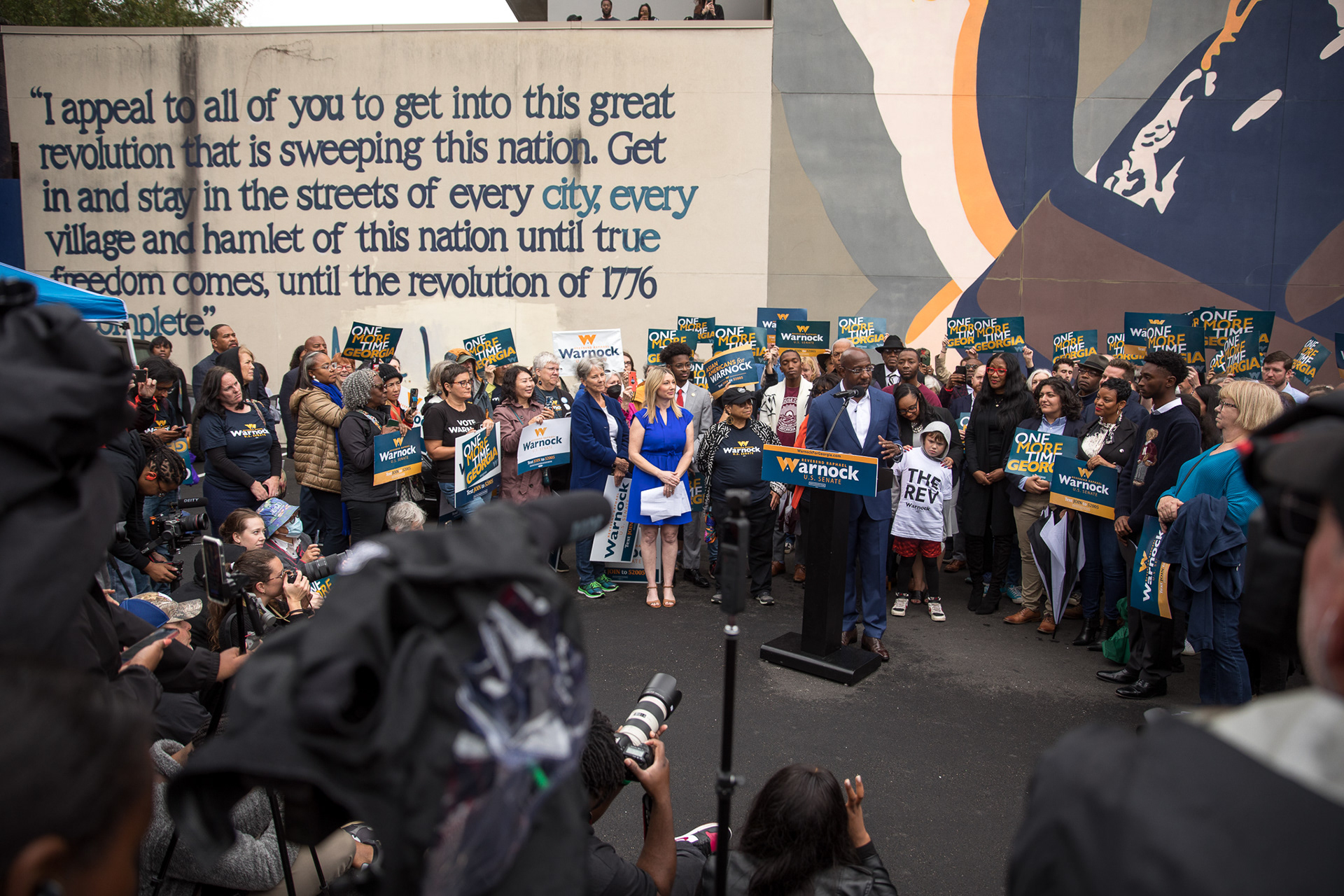 U.S. Sen. Raphael Warnock gathers with supporters in front of the John Lewis mural in Atlanta.