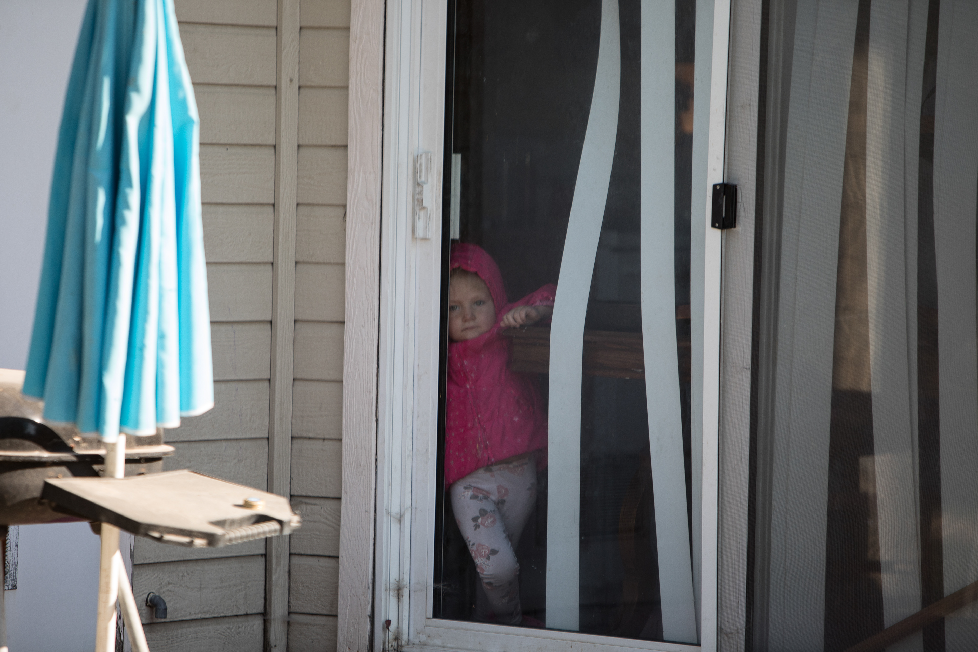 Jaelynn, 2, watches Wednesday afternoon from a separate apartment building as Nampa Police search a unit in connection with a Sept. 25 deadly shooting.