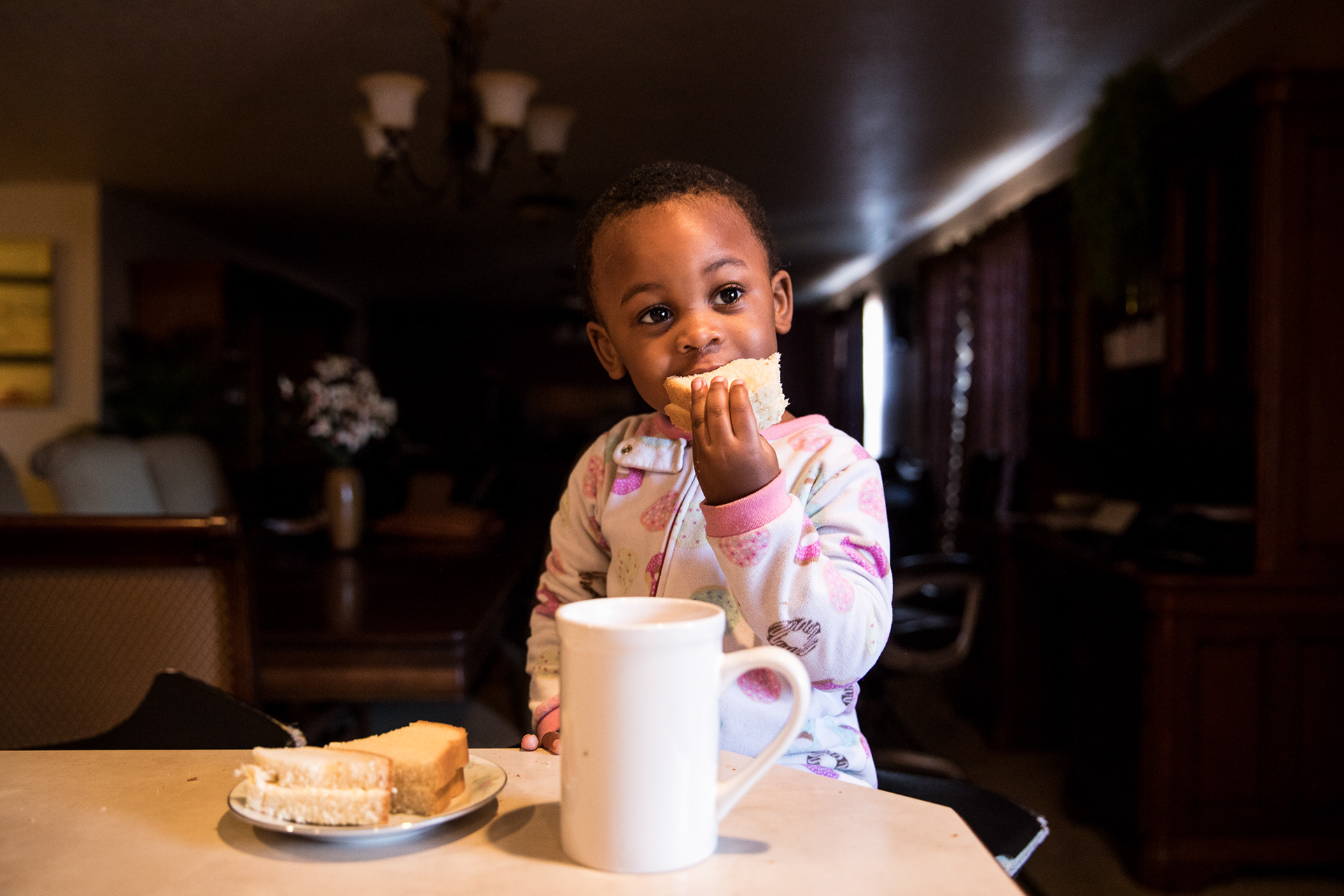 Hagath Mwamba's son, Joshua, 3, eats a bread sandwich for breakfast in their family home in Boise on Feb. 6.