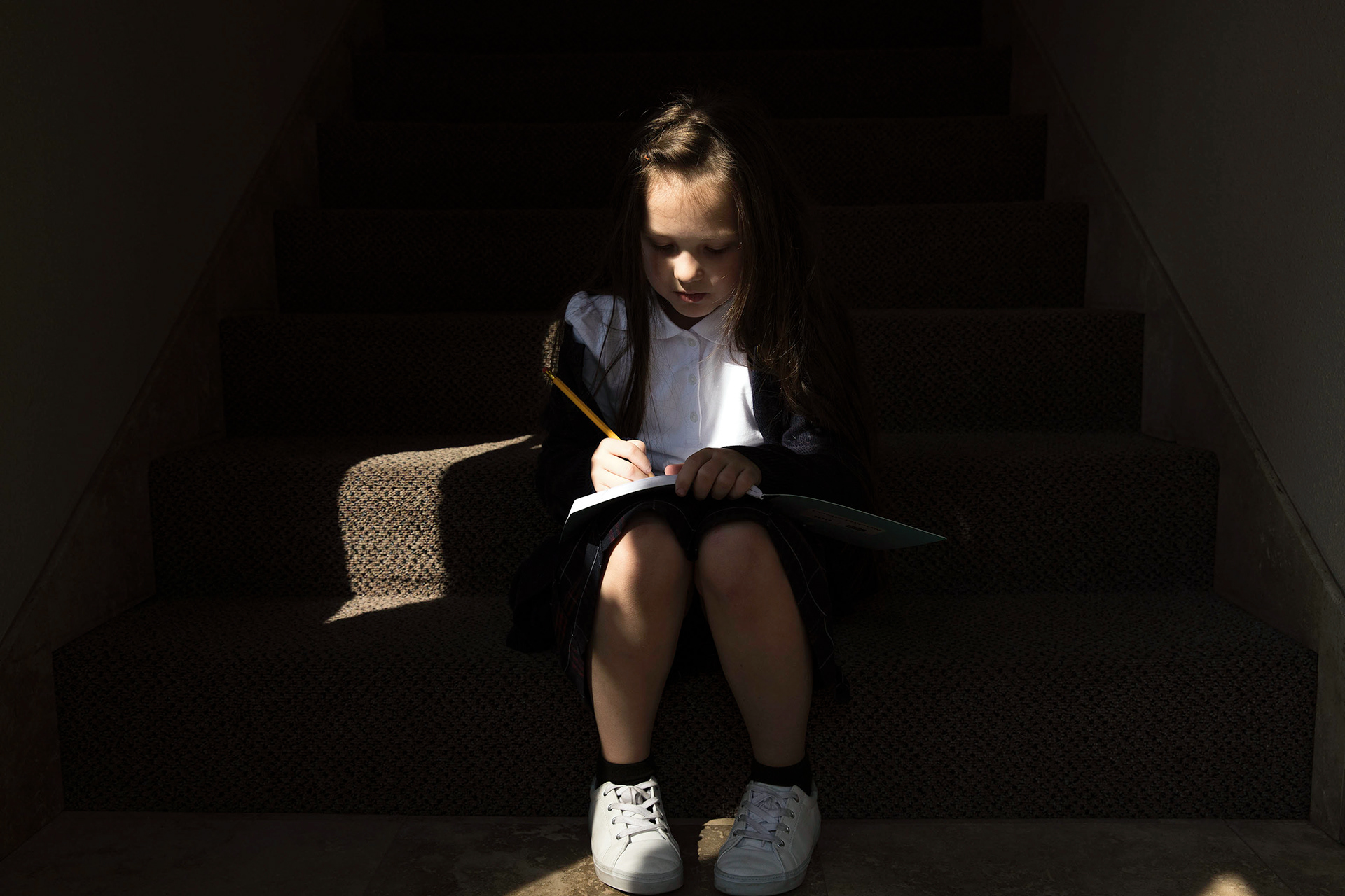 Third-grade student Sasha Ignatiuk, 8, draws a cat as she waits for her mom after school at the Petra Academy on Sept. 12 in Boise.