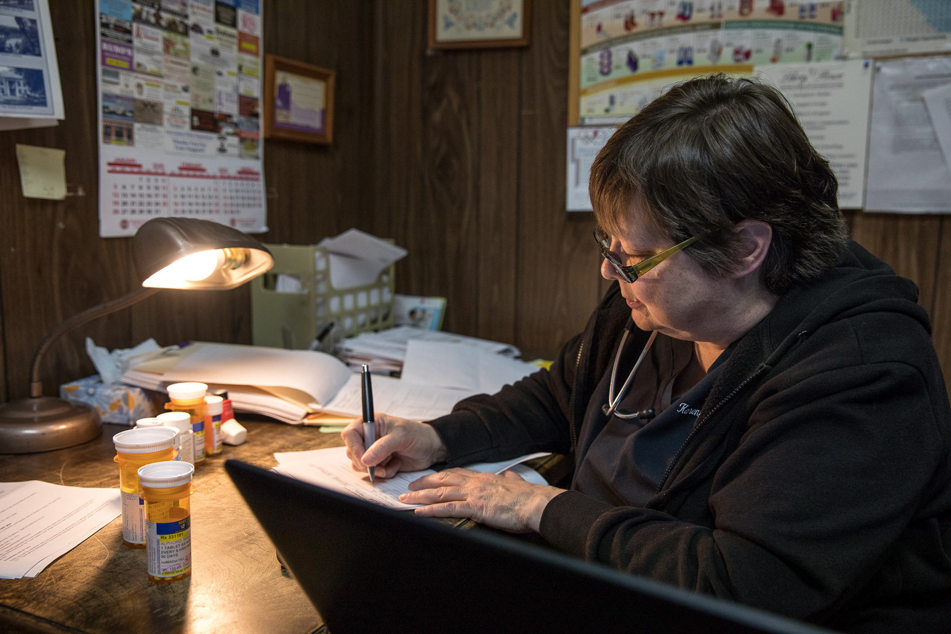 Dr. Karen Kinsell, 64, writes down prescriptions and doses for patients in an exam room at the Clay County Medical Center on Jan. 8 in Fort Gaines.