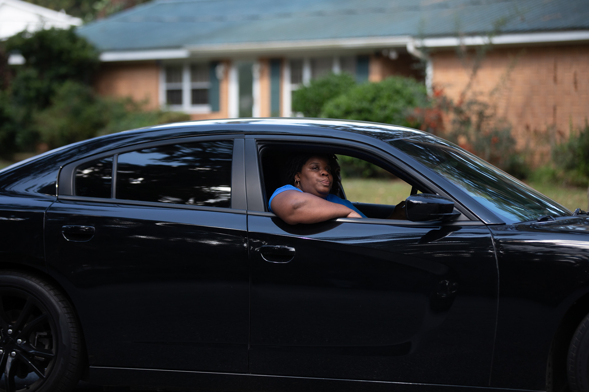 Ahmaud Arbery’s aunt Theawanza Brooks, rides in a car down Satilla Drive, the street where her nephew took his last breath, during a car procession in Brunswick on Oct. 16, 2021.