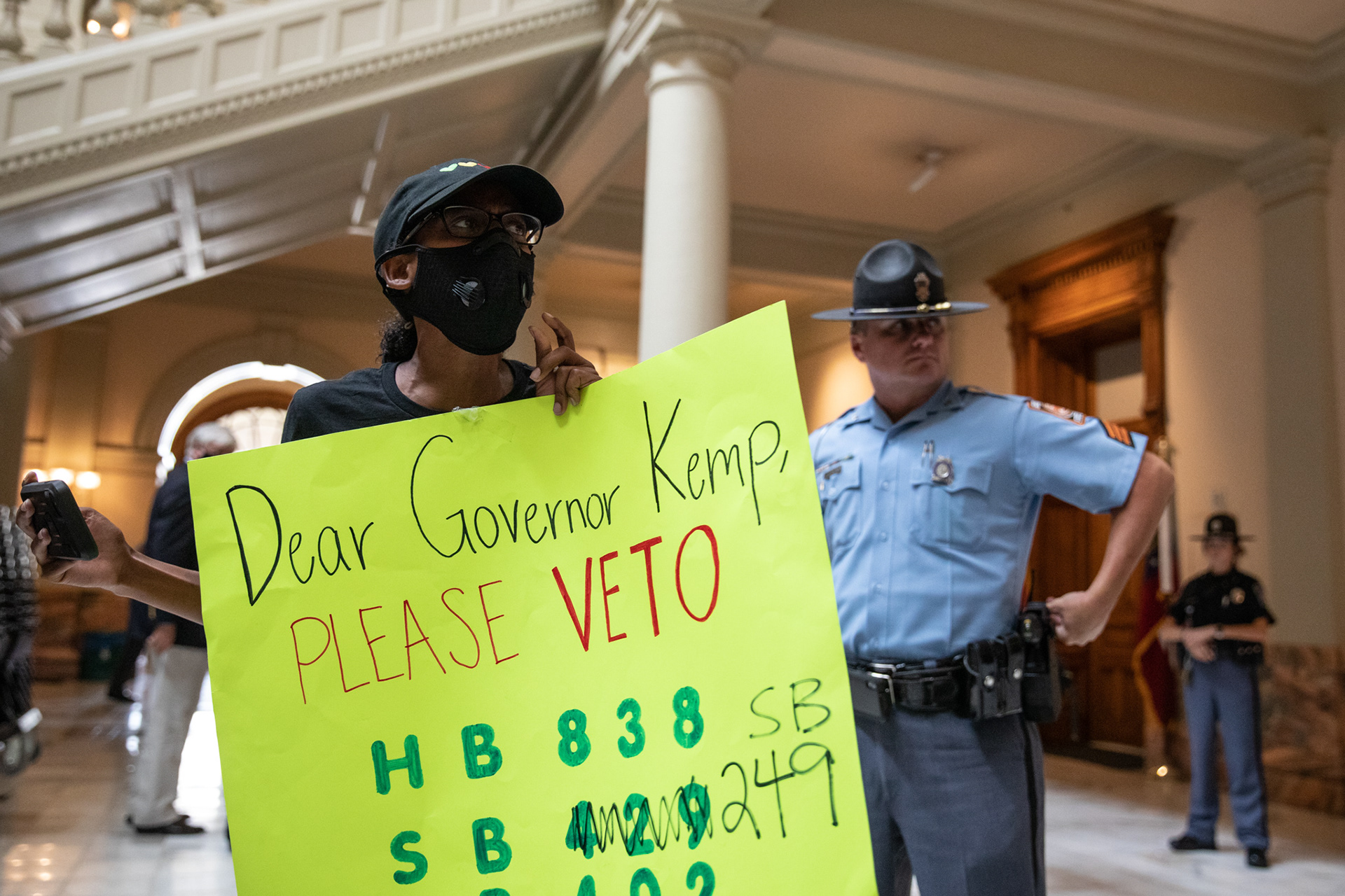 Hannah Gebresilassie and a small group of protesters urge Gov. Brian Kemp to veto House Bill 838, legislation that gives protections to police officers on June 26.