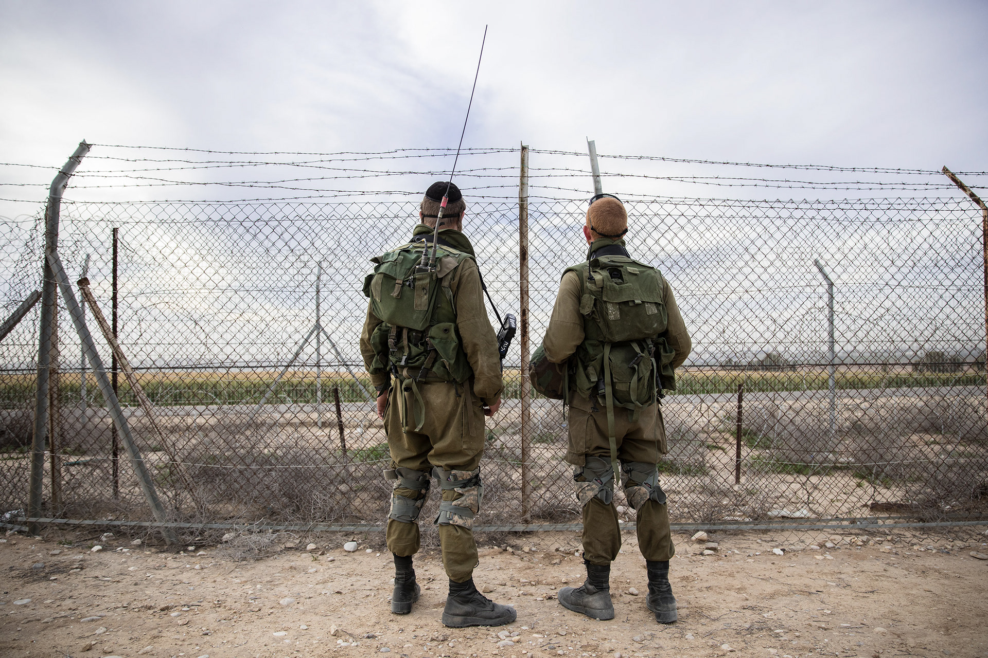 Two Israeli soldiers patrol the border of the Gaza Strip. Less than a half a mile away, the pair only in their second week of training, watch for tanks, rockets and other threats to the border-ing villages. This time, Hamas militia seemed to be transporting troops from one area of the border to an unknown location. This activity is unusual, one of the soldiers said, so they will remain on a close watch.
