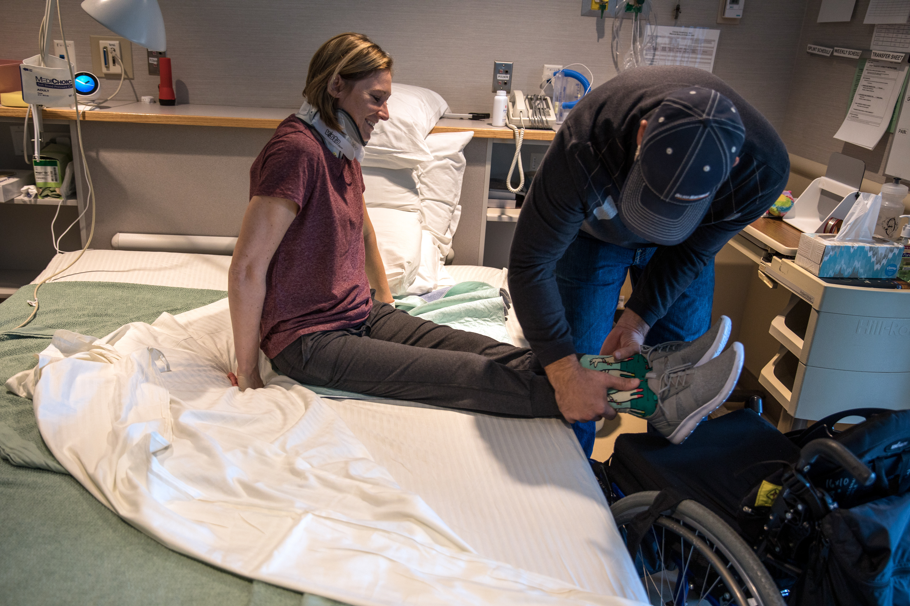 Lee Abrams helps Nikeela Black transfer from her hospital bed to her wheel chair at Craig Hospital on Sept. 17.