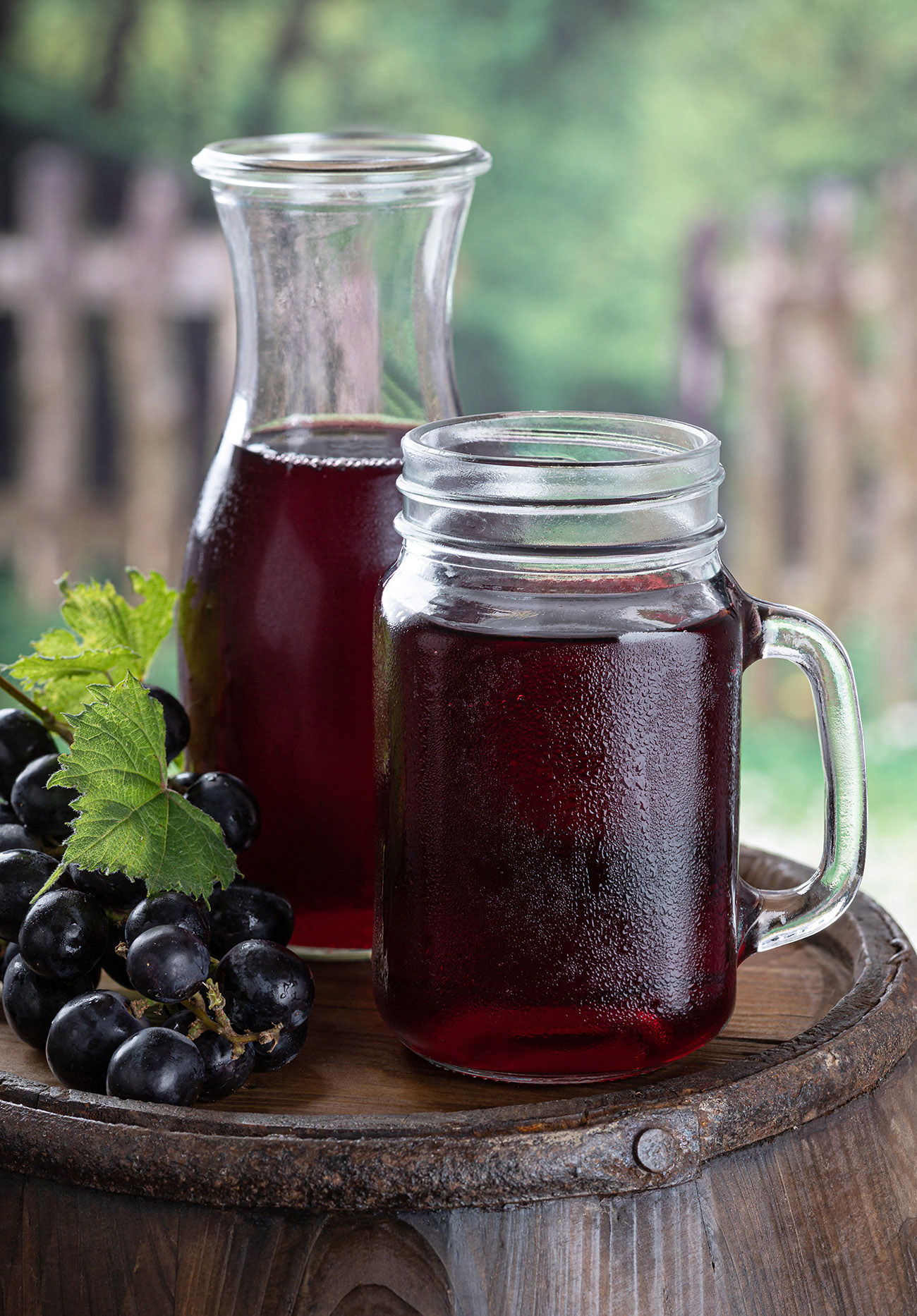 Glass of grape juice on a wooden barrel