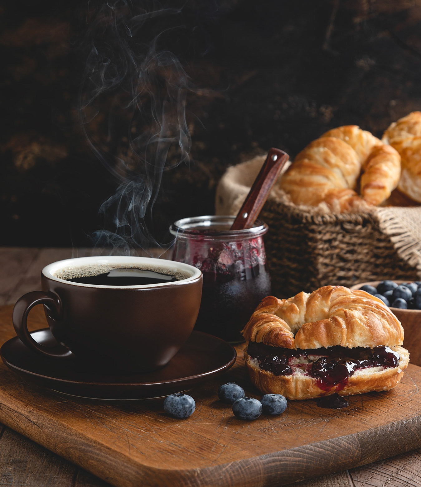 Steaming cup of coffee and croisants