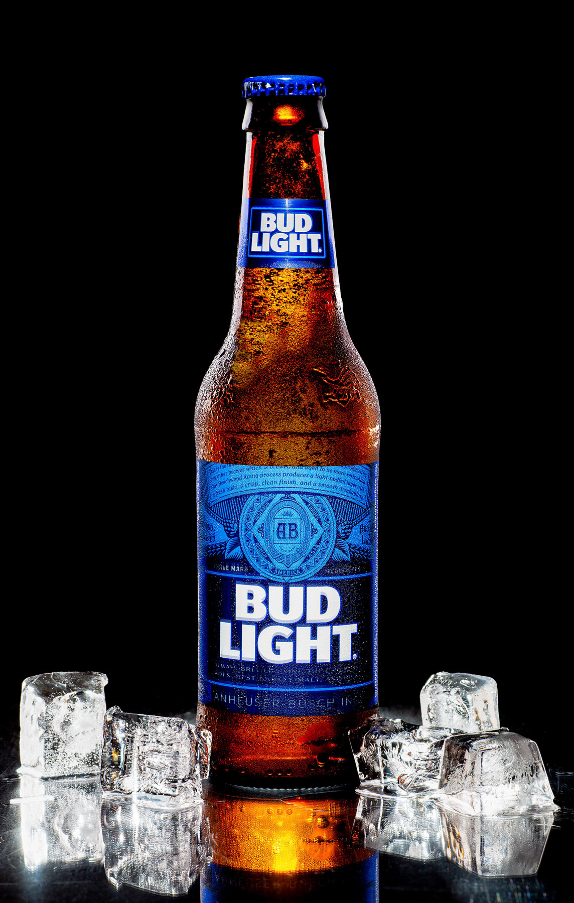 Bottle of cold Bud Light on black background