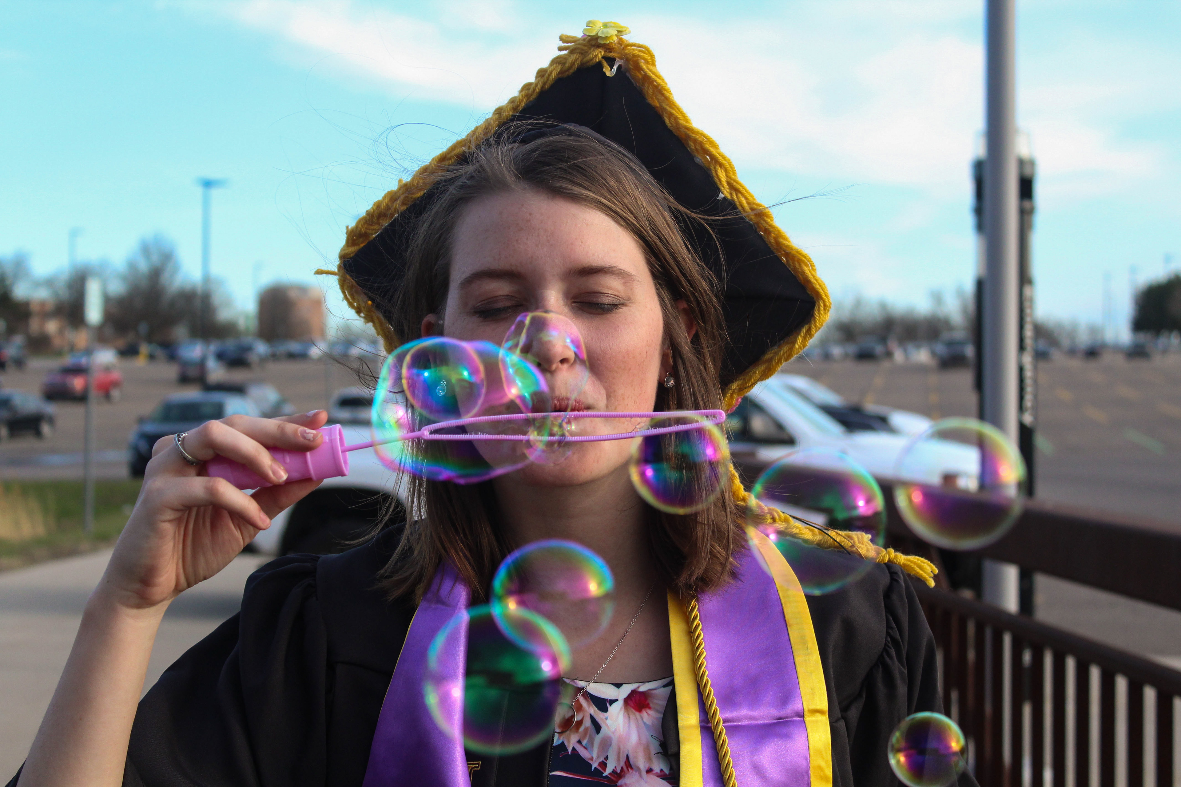 April 2019 | Graduation portrait of Katie blowing bubbles at the camera