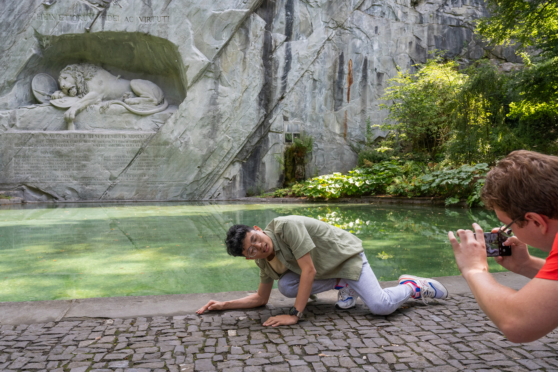 Ein Tourist lässt sich vor dem Löwendenkmal in Luzern fotografieren