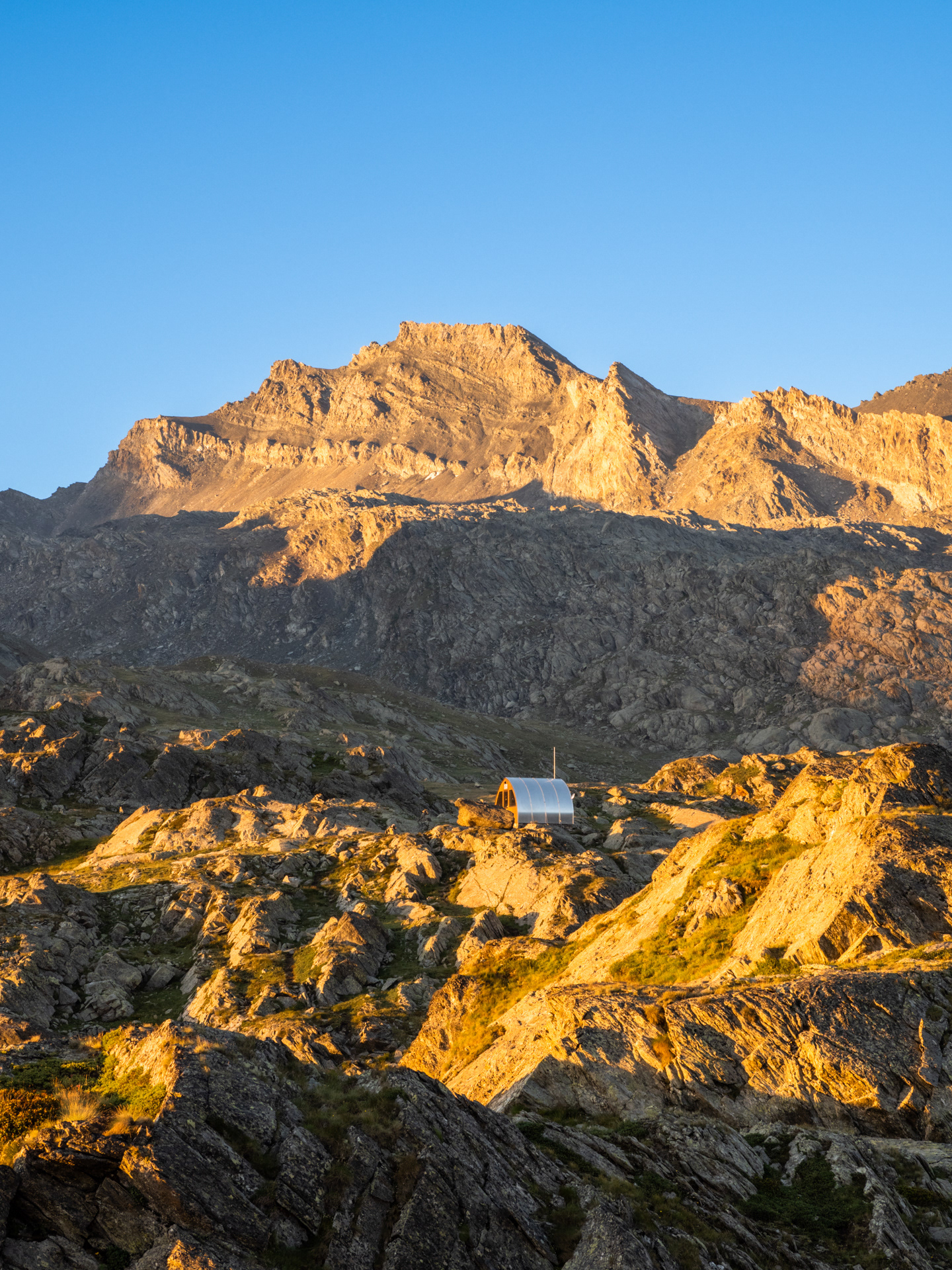 Il Bivacco Enrico Olivero all'alba dinnanzi al Monte Salza