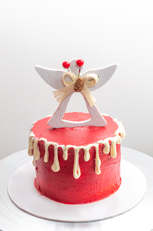 Christmas themed cake with white chocolate drip decorated with a topper