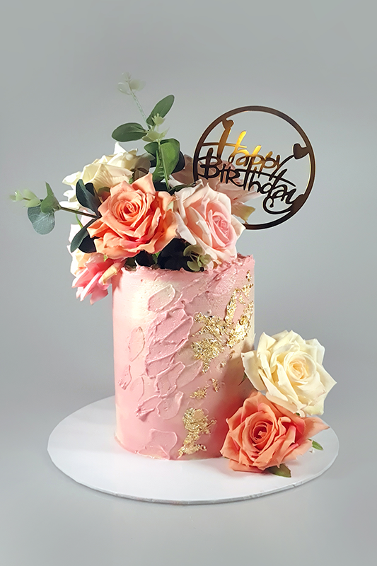 Cake with pink shade butter cream frosting. Decorated using using a Palette knife and edible gold leaf