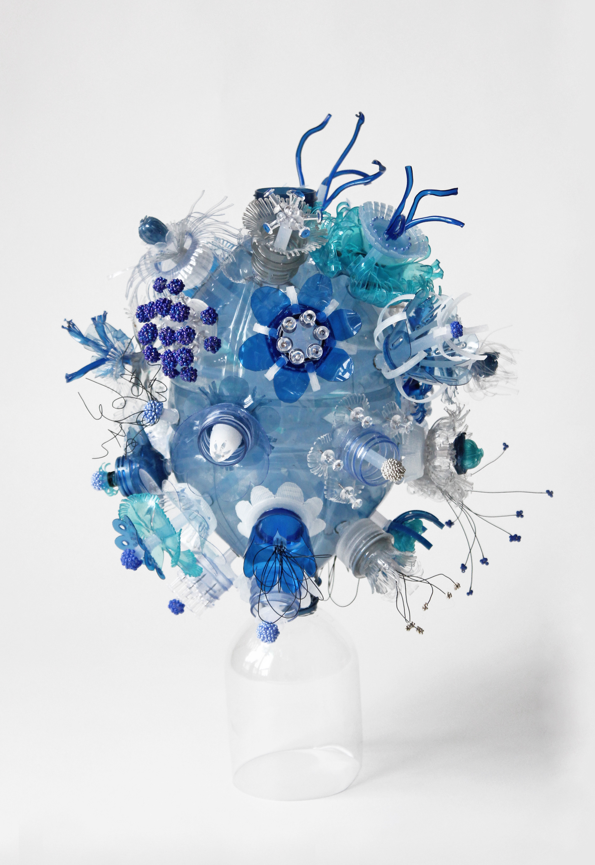 Floral Figures on Double-Rimmed Plastic Bottle, 2022 Mixed Media (Upcycled plastic, glass beads, metal) 15x25 in installation
