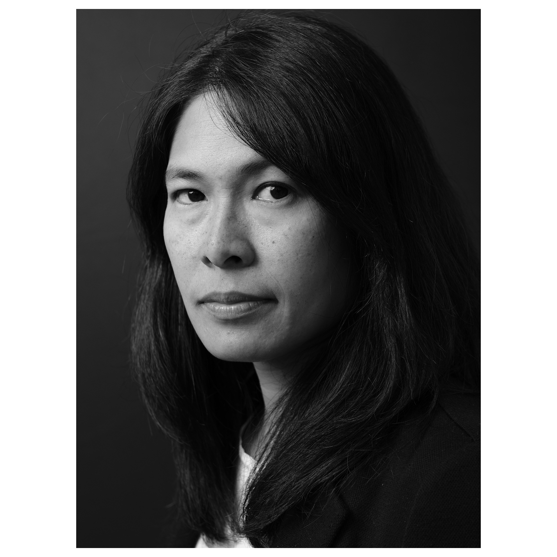 Ritratto in bianco e nero con sfondo nero e flash di una donna dai lineamenti asiatici
