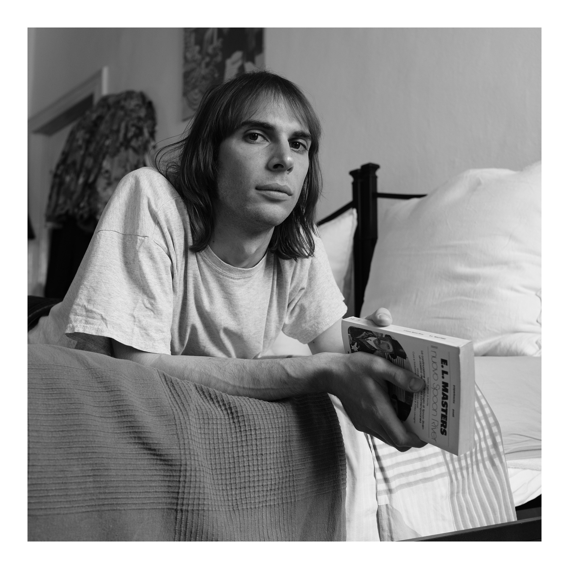 Ritratto in bianco e nero di Alessio con in mano un libro di poesie - progetto fotografico di Andrea Palumbo