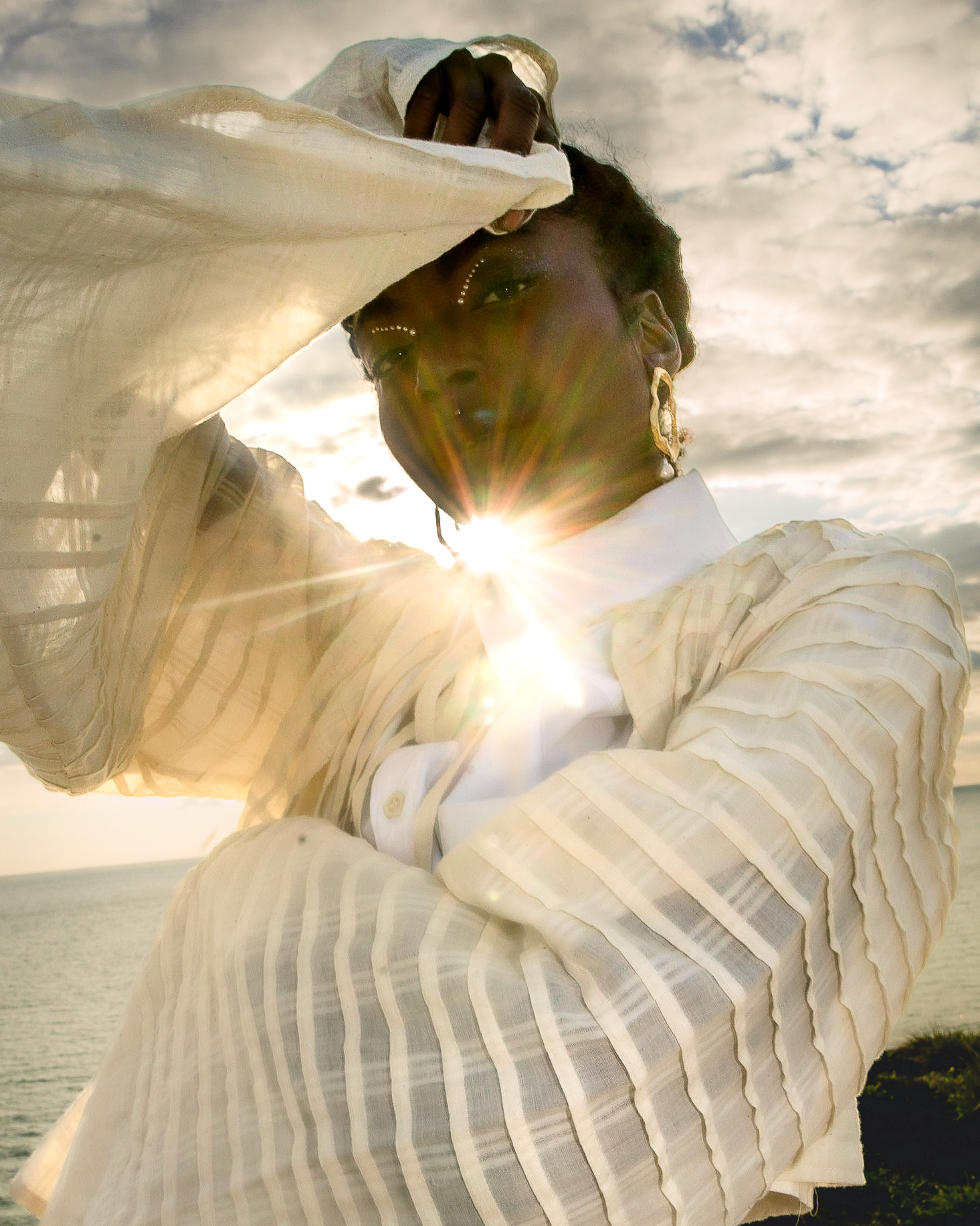 Fashion Editorial shot with a black model. The sun setting behind her as she poses. Shot by Amin McDonald, featured in Noctis Magazine.