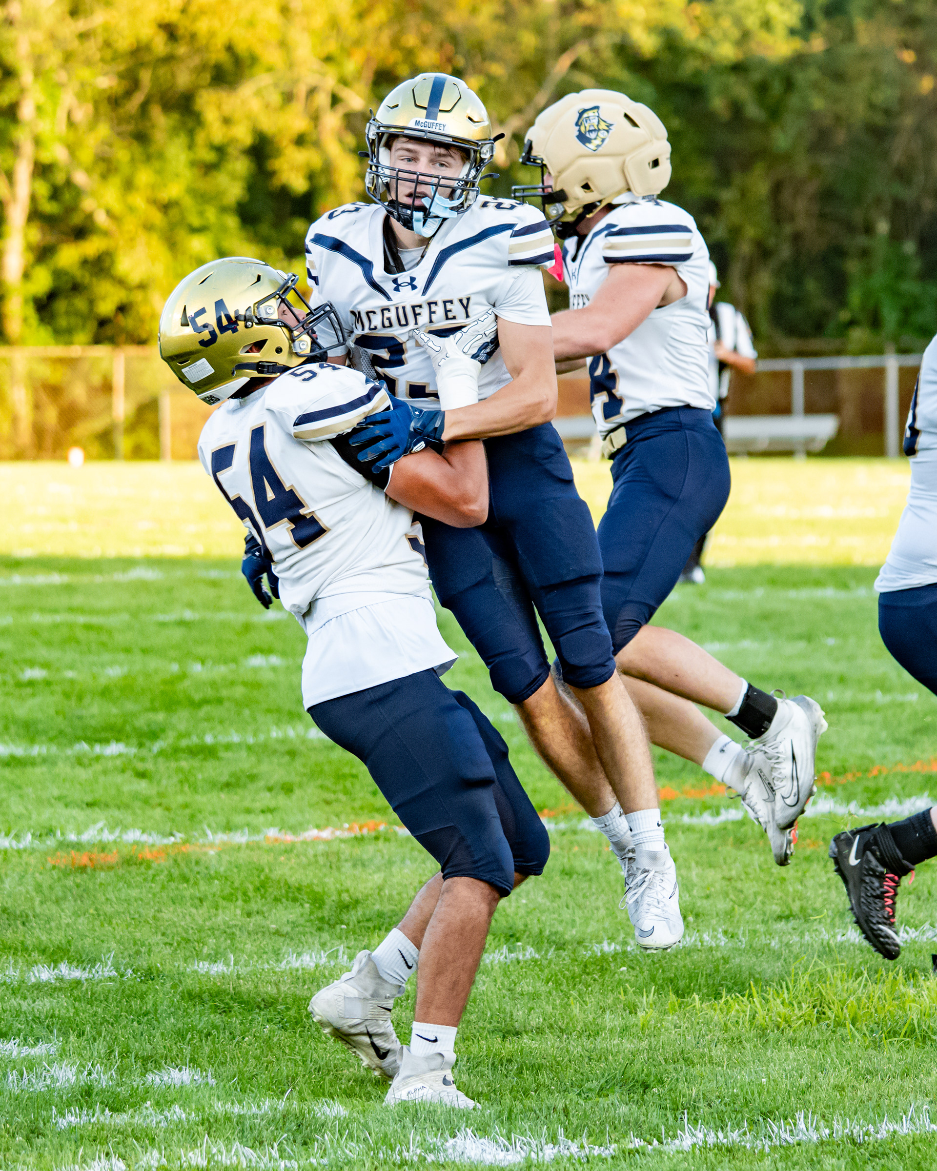 McGuffey's Evan Conklin (54) celebrates with teammates Dristen McAnallen (23) and Paul Speer (44) after Dristen's touchdown during a game against Bentworth on Friday, Aug. 28, 2026, at Ellsworth Athletic Field in Bentleyville, Pa.