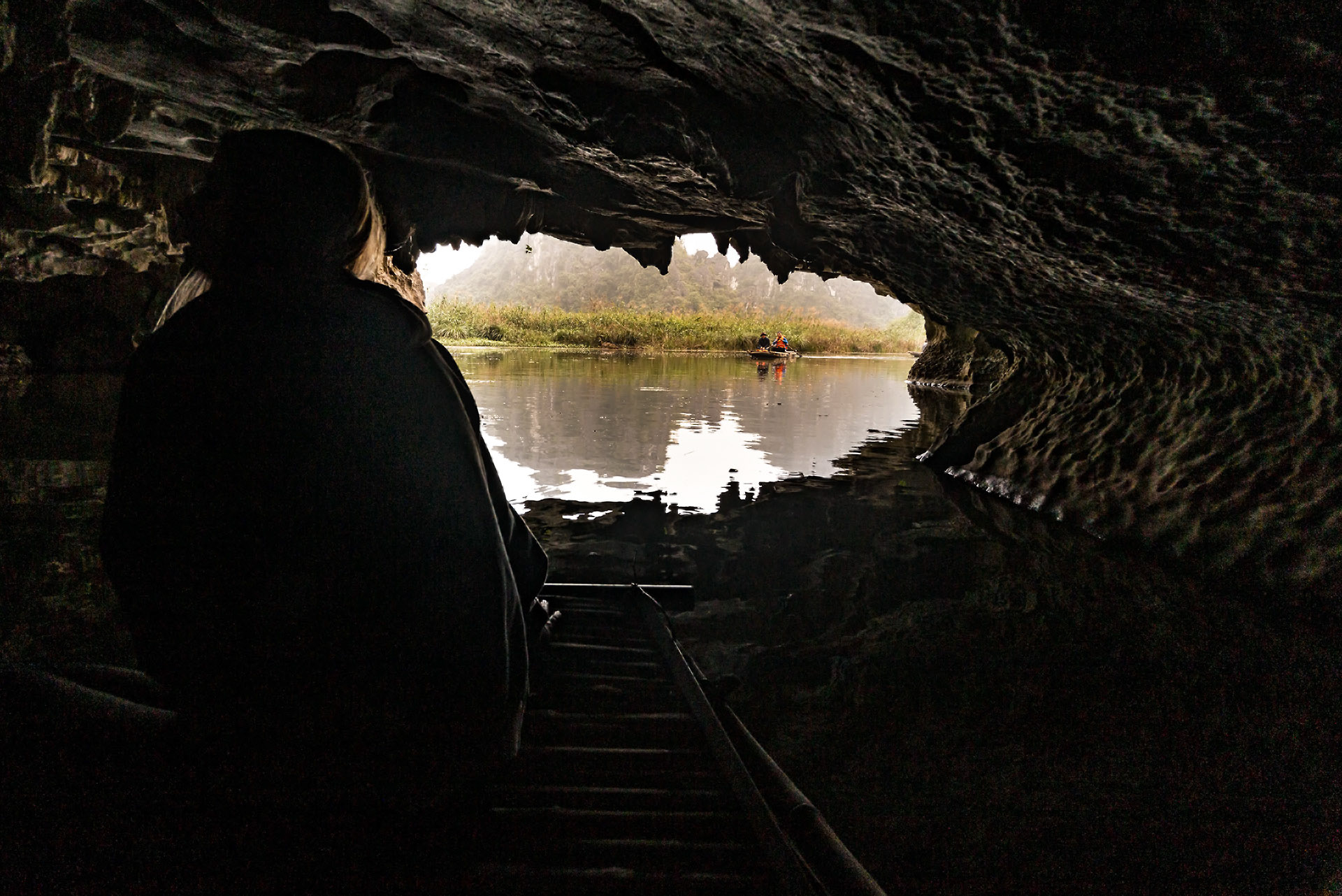 Blick aus einer befahrbaren Höhle auf die Landschaft in Van Long.