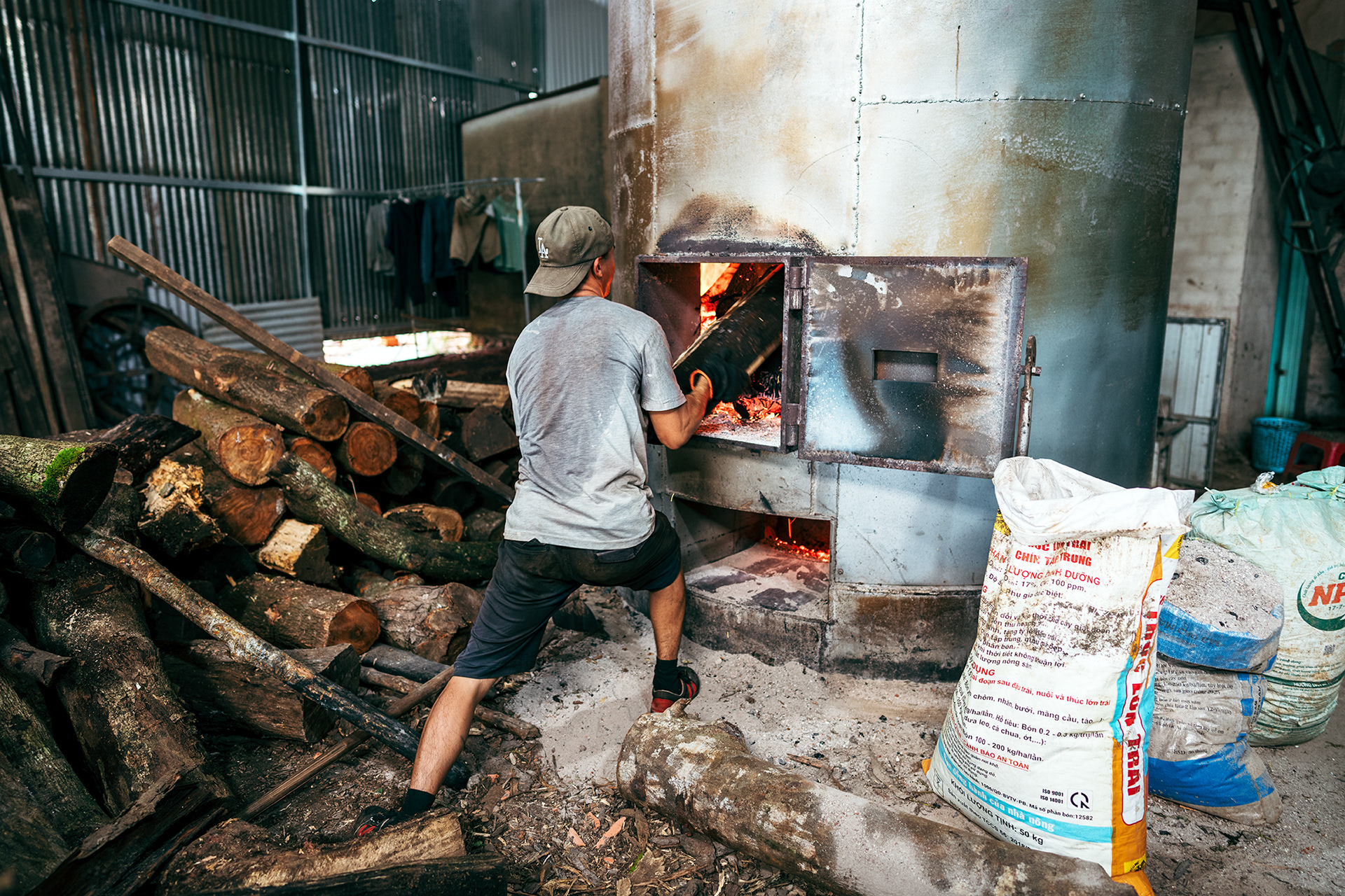 Ein Mitarbeiter schiebt Holz in den riesigen Ofen.