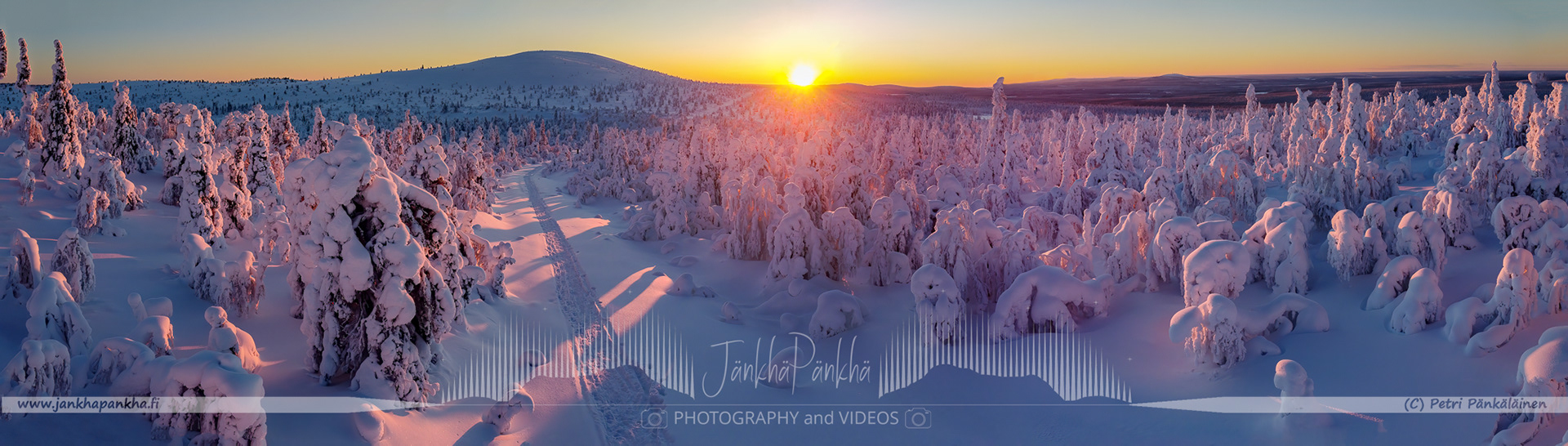 Vibrant orange and yellow hues painting the sky during a polar night in Lapland's Pallas-Yllästunturi National Park. Silhuette of the Sammaltunturi in the horizon.
