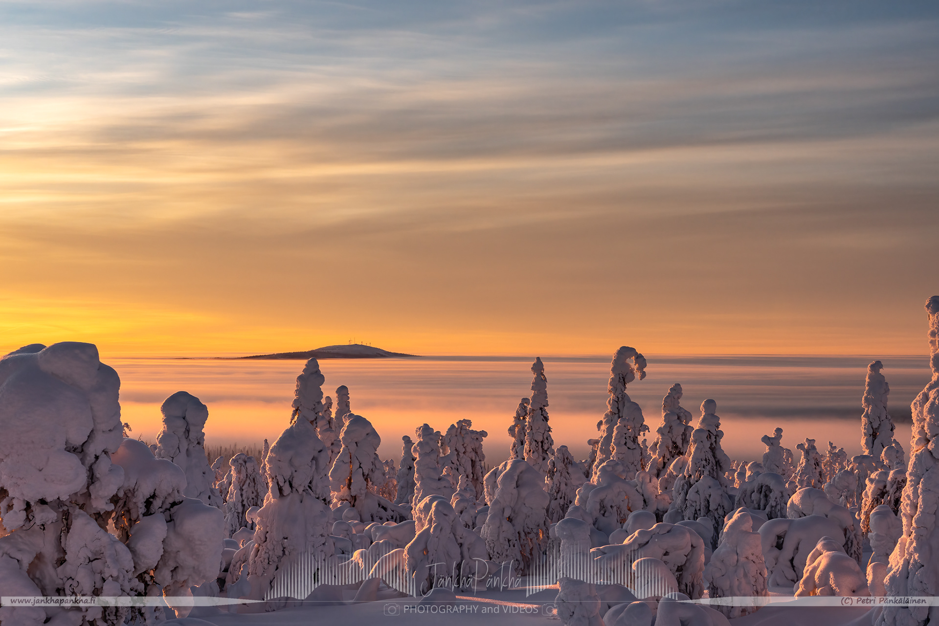 The valley covered with the low hanging clouds nearby the Pallastunturi fell. The Olostunturi fell and Muonio city in the horizon.